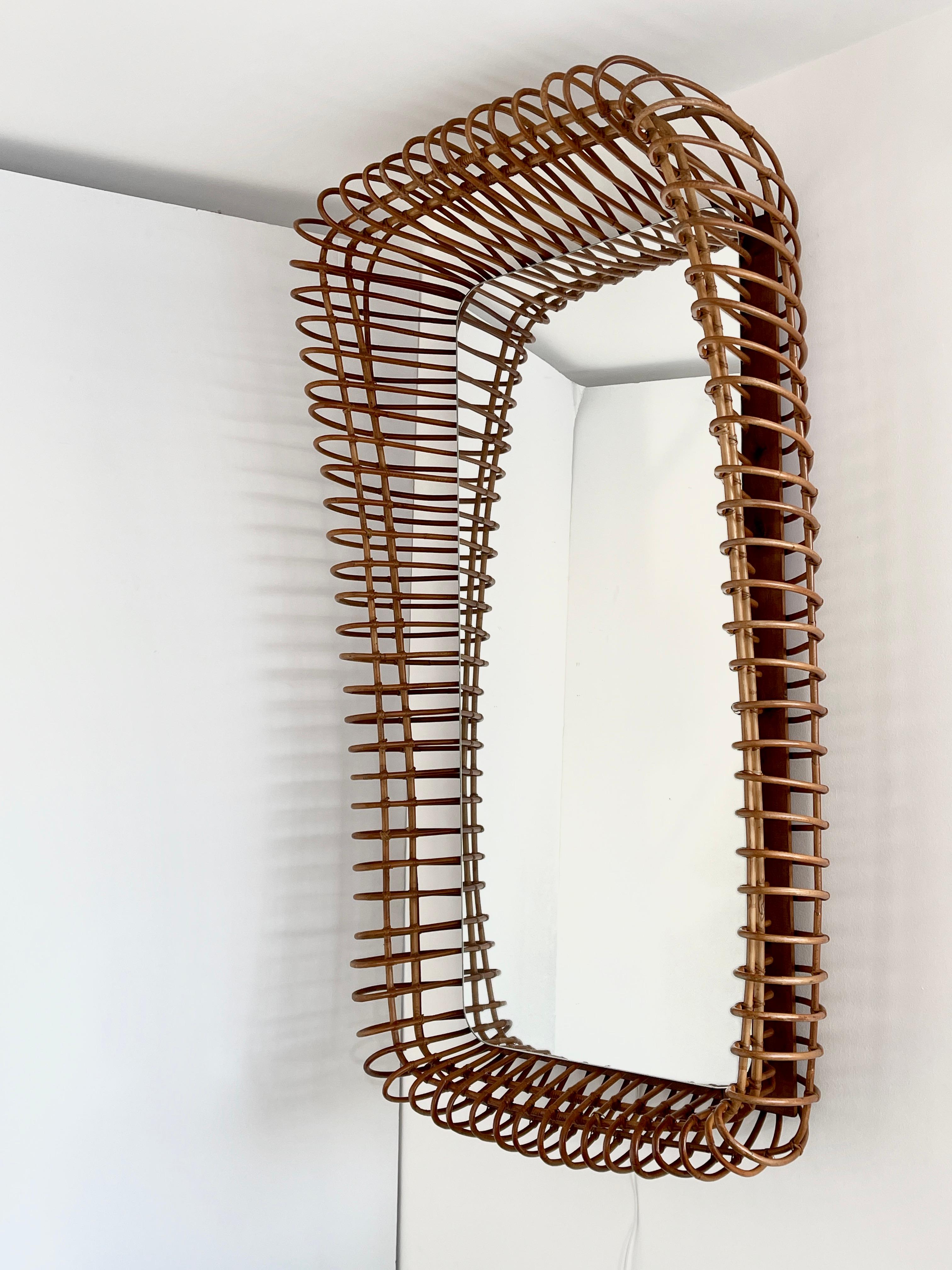 1950's French bamboo mirror - gigantic in scale - with curved edges projecting off the wall - larger at the top than the bottom. 
Newly rewired and lights from behind the mirror. 
One of a kind piece!