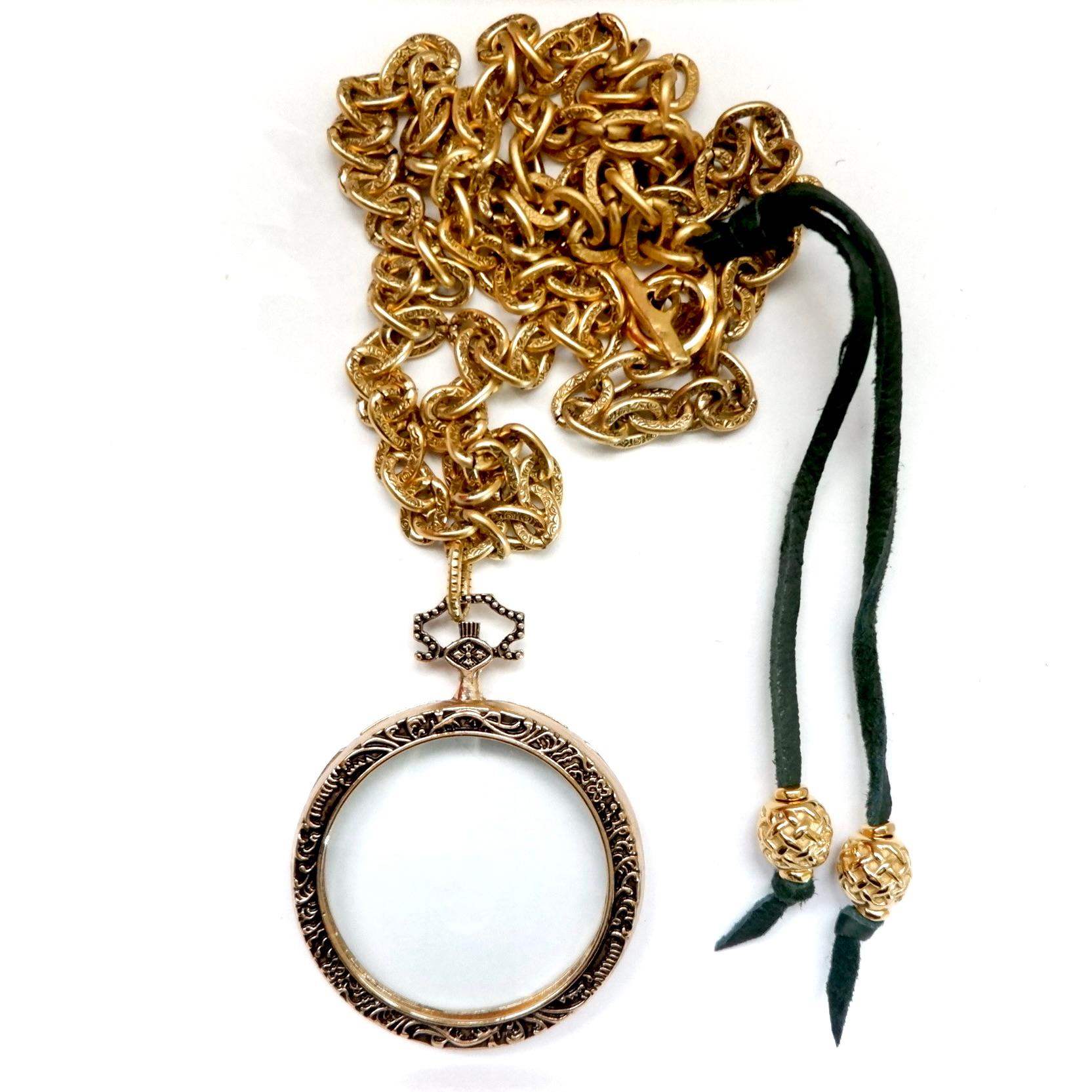 This handcrafted, one-of-a-kind necklace is a true masterpiece of style and craftsmanship. At its heart lies a stunning vintage magnifying glass pendant, a striking focal point that blends antique allure with contemporary flair. The pendant's