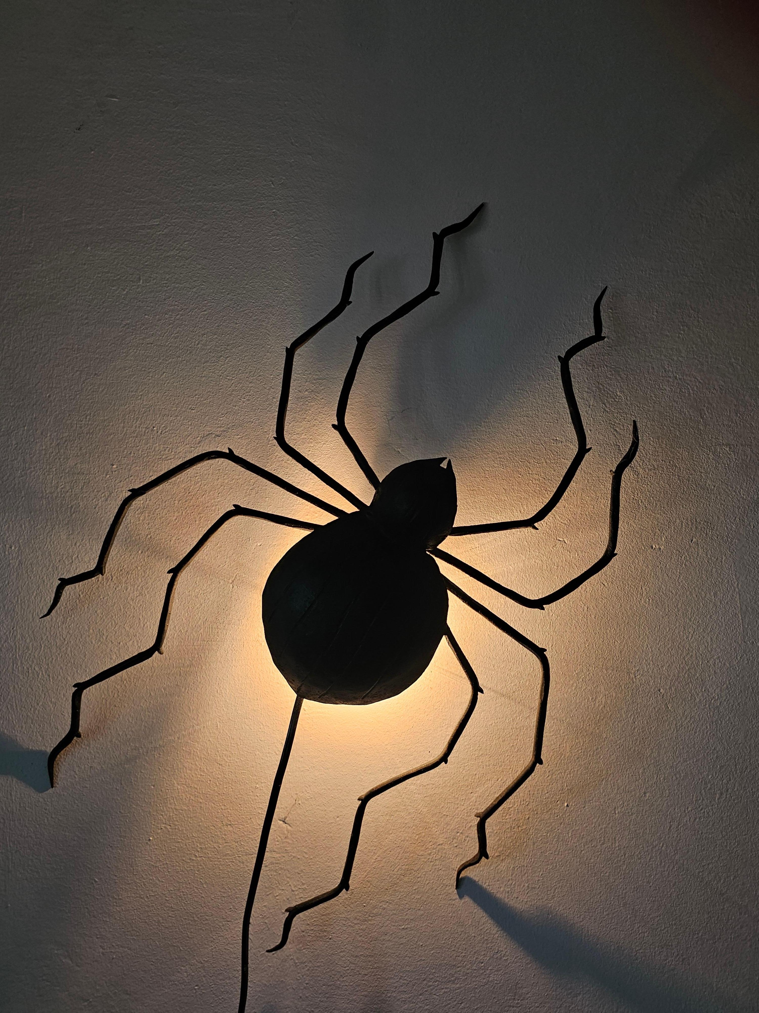 En este anuncio encontrarás un espectacular candelabro grande Mid Century Modern (o más bien Brutalista) con forma de araña. El candelabro es de hierro negro y tiene una bombilla oculta tras el cuerpo de la araña. Fabricado en Alemania Occidental en