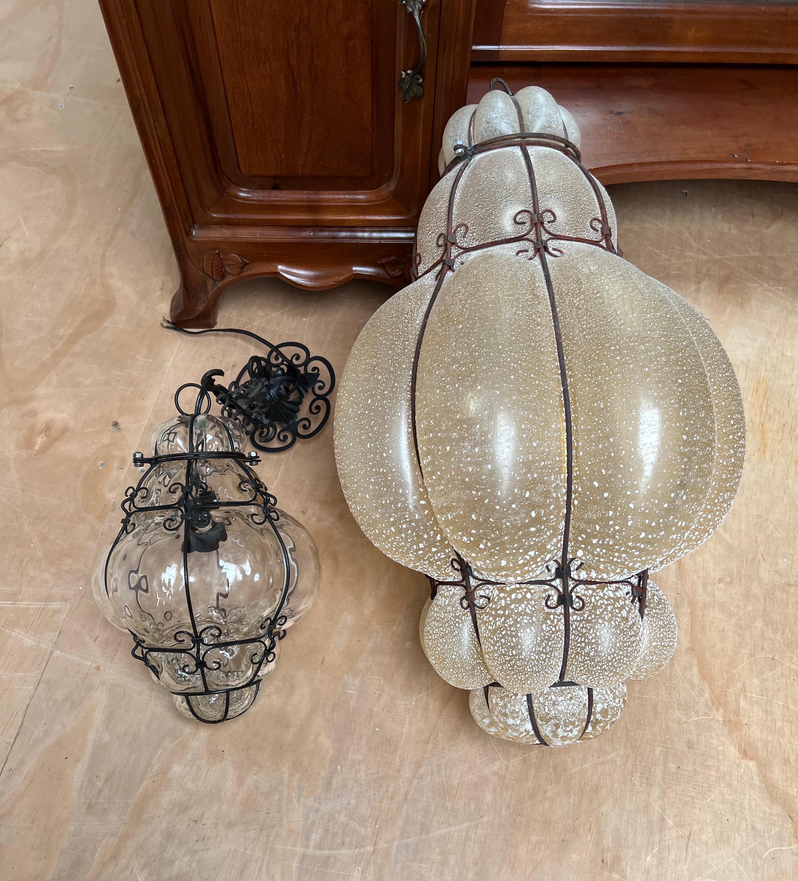 Arts and Crafts Grande paire de lampes à suspension vénitiennes, verre ambré soufflé à la bouche dans un cadre en fer forgé  en vente