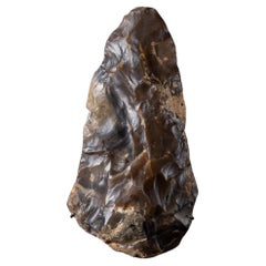 Utensile paleolitico "gigante" con patina arancione-marrone, realizzato dai primi esseri umani