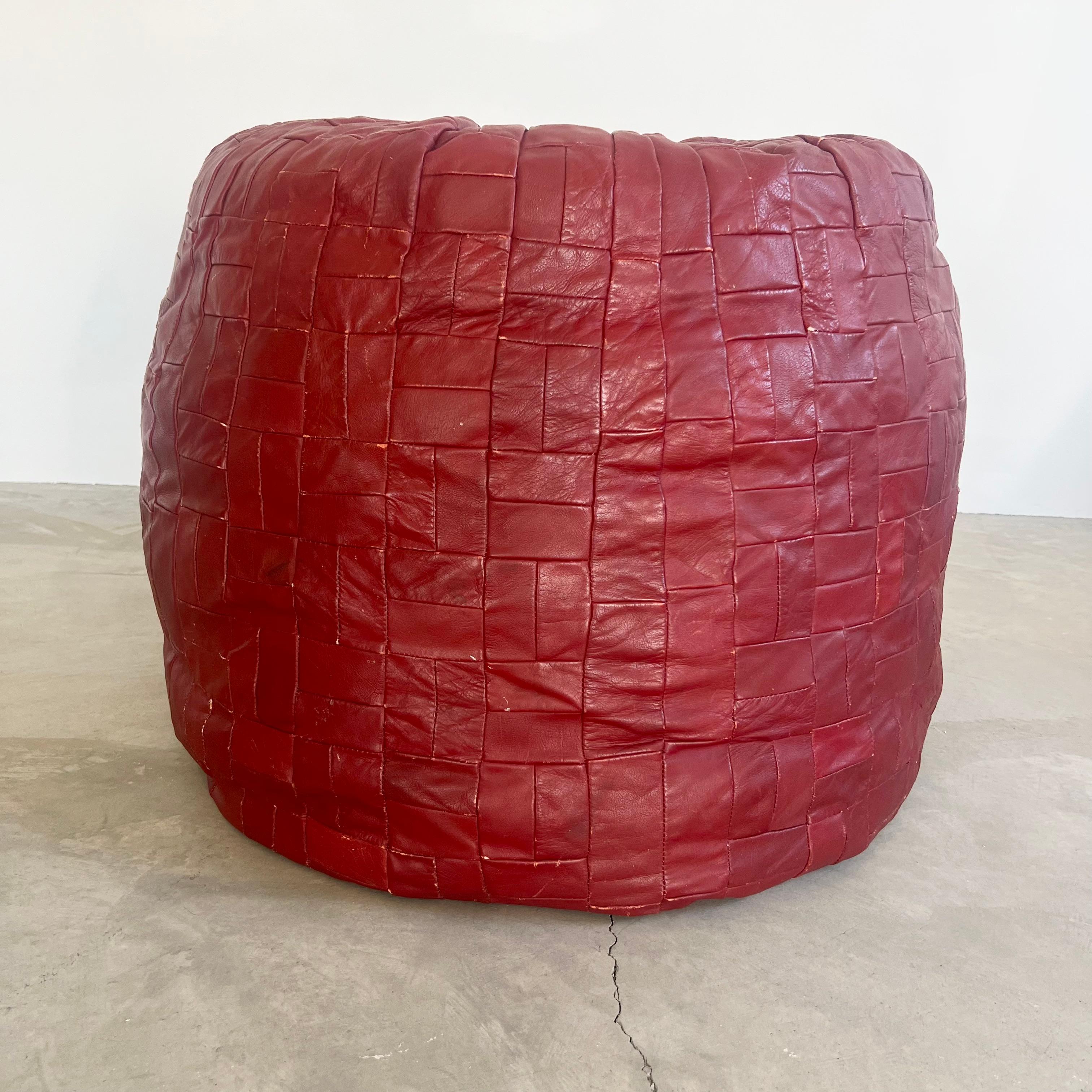 Giant patchwork leather ottomans by De Sede, Switzerland. Made in the 1970s. Deep burgundy color. Great patina and coloring to leather. Extremely unusual in that they are giant cylinders. Massive scale, just over 2 feet tall and just under 3 feet