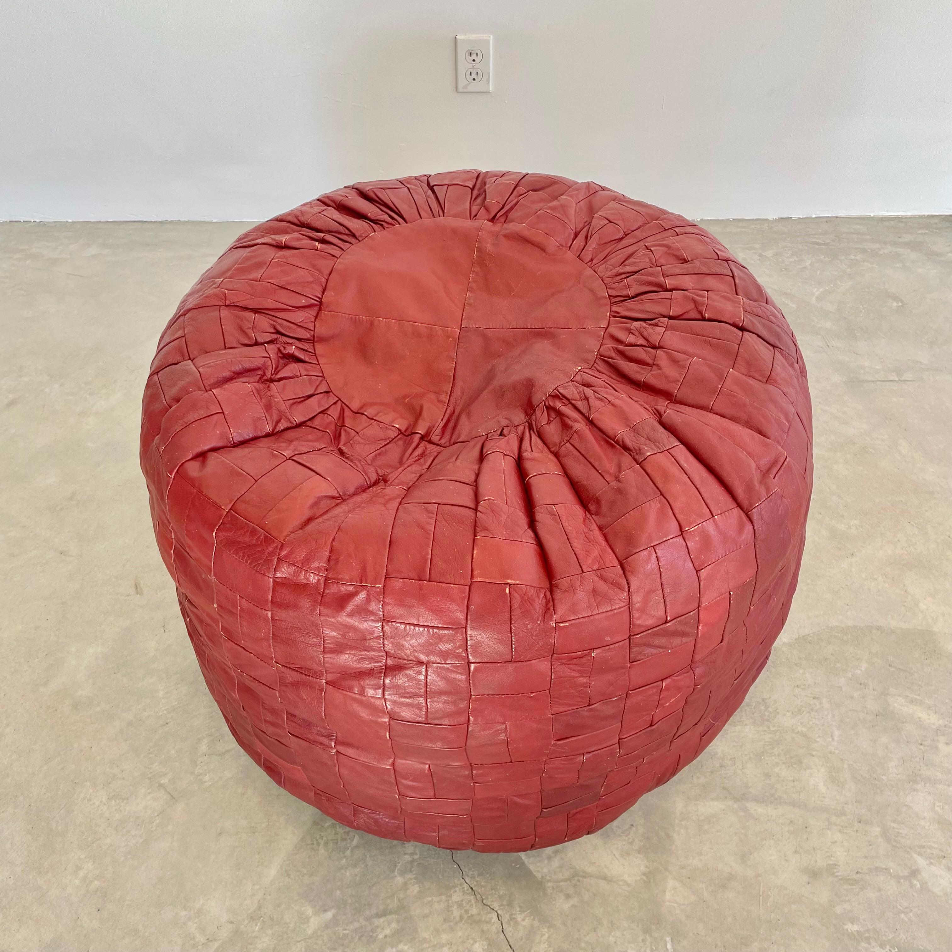Giant patchwork leather ottomans by De Sede, Switzerland. Made in the 1970s. Deep burgundy color. Great patina and coloring to leather. Extremely unusual in that they are giant cylinders. Massive scale, just over 2 feet tall and just under 3 feet