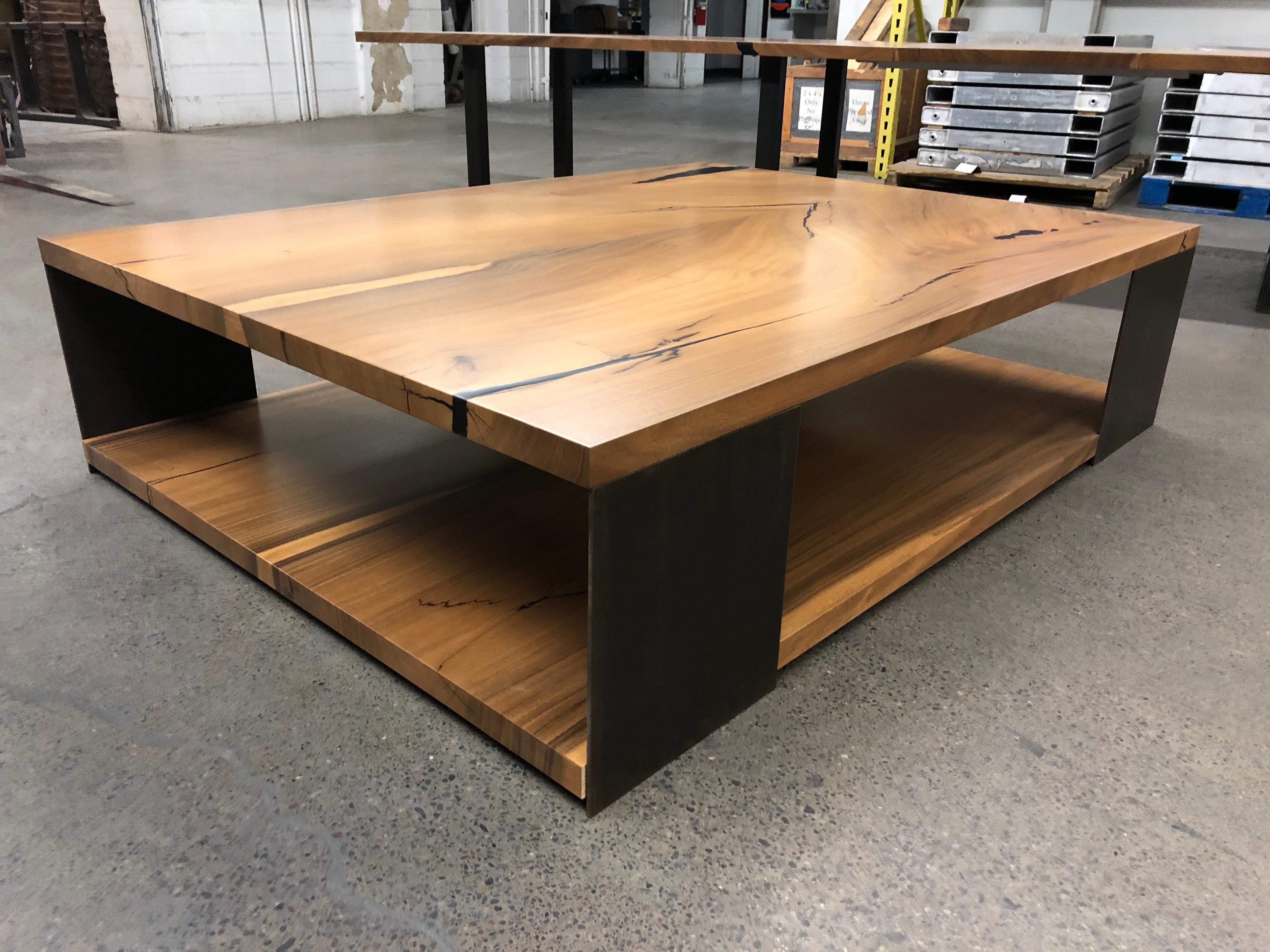A two level monkeypod coffee table - each level is bookmached and the clean metal legs lock them sturdily in place for a pretty spectacular coffee table. 

The table in the image is long since sold to the client that custom ordered it. You would be