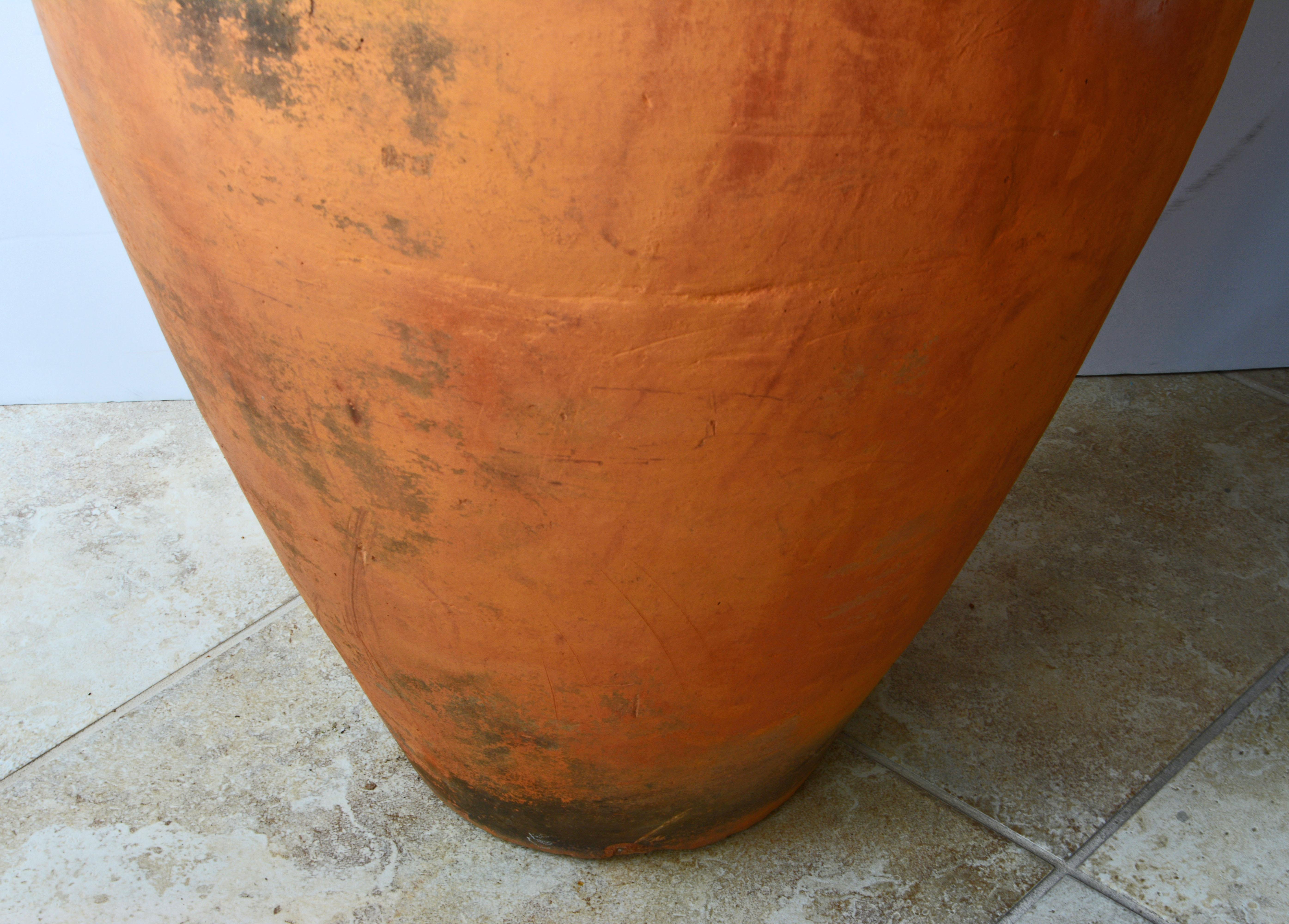 Standing more than 44 inches tall this vintage terracotta olive jar will make a great impression indoors as well as outdoors. Of classic form It features a wide flared mouth and two sculpted handles.
