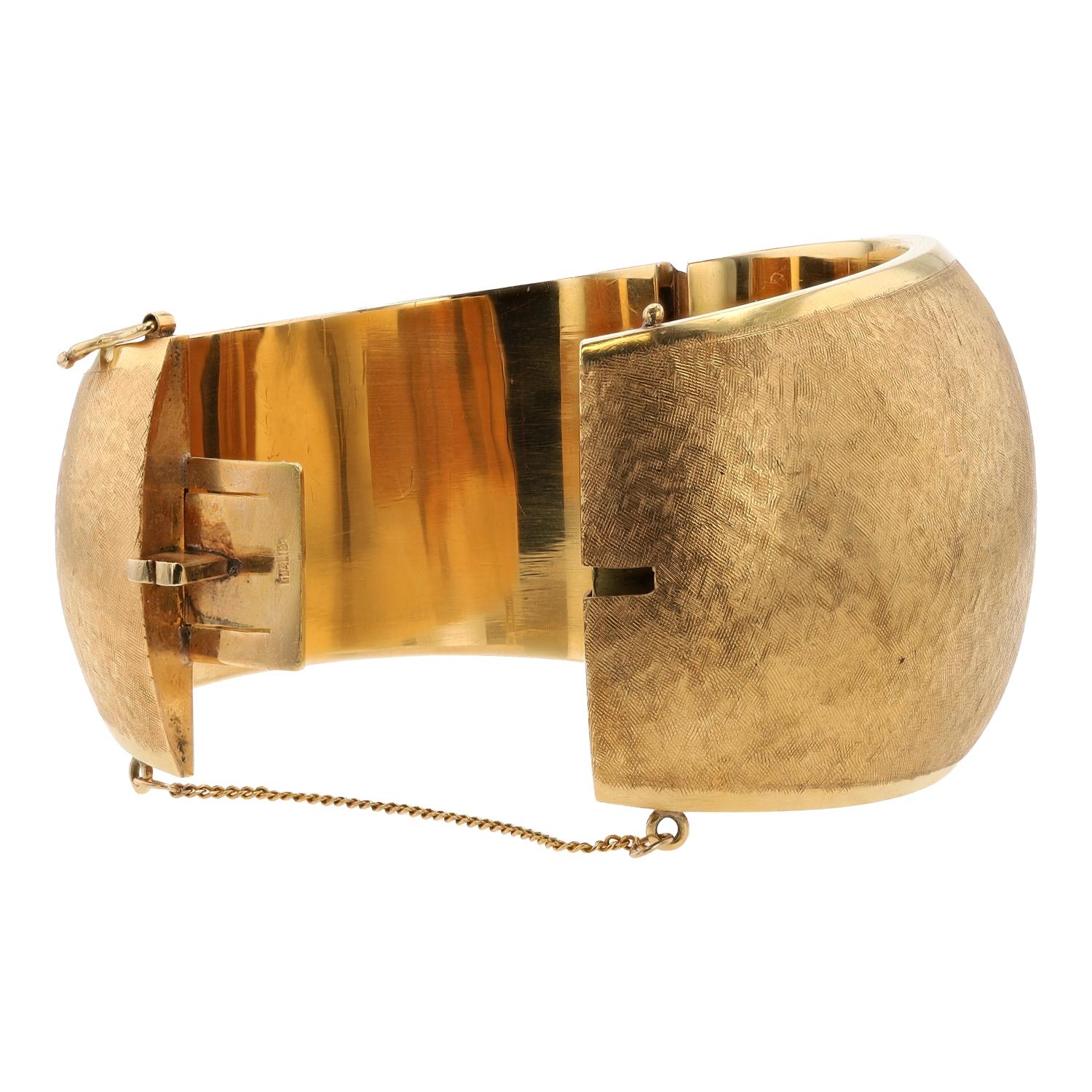 Esta magnífica pulsera brazalete vintage de oro italiano de 18 quilates es toda una declaración de glamour de los años 80. Con un peso de 4 onzas y un acabado perfecto con un sutil dibujo florentino (oro cepillado), este clásico atemporal es una