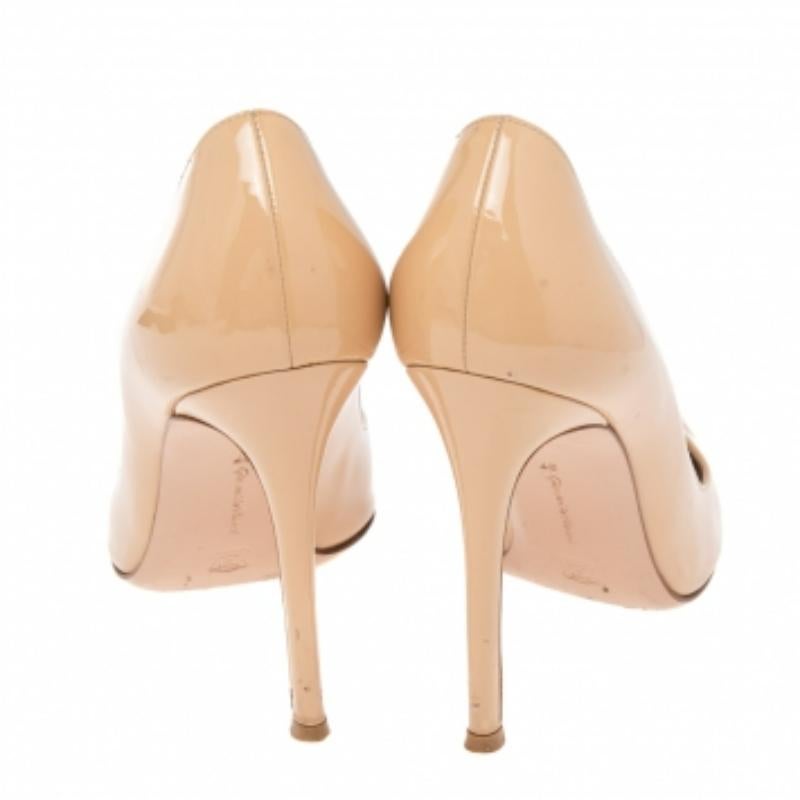 A feminine flair, sleek cuts, and a timeless appeal characterize these stunning Gianvito Rossi pumps. Crafted from patent leather in a beige shade, they are designed with pointed toes and are raised on stiletto heels.