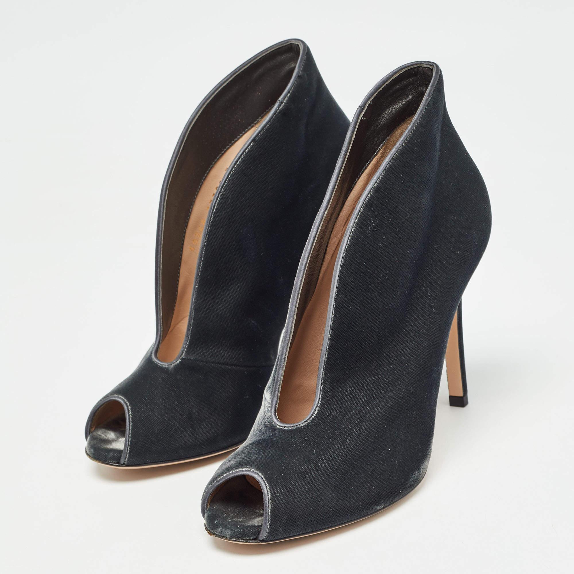 Ajoutez une touche d'originalité à votre tenue avec ces bottines Gianvito Rossi. Fabriqués en velours, ils présentent des orteils en forme de peep toes, des empeignes ouvertes et des talons aiguilles.
