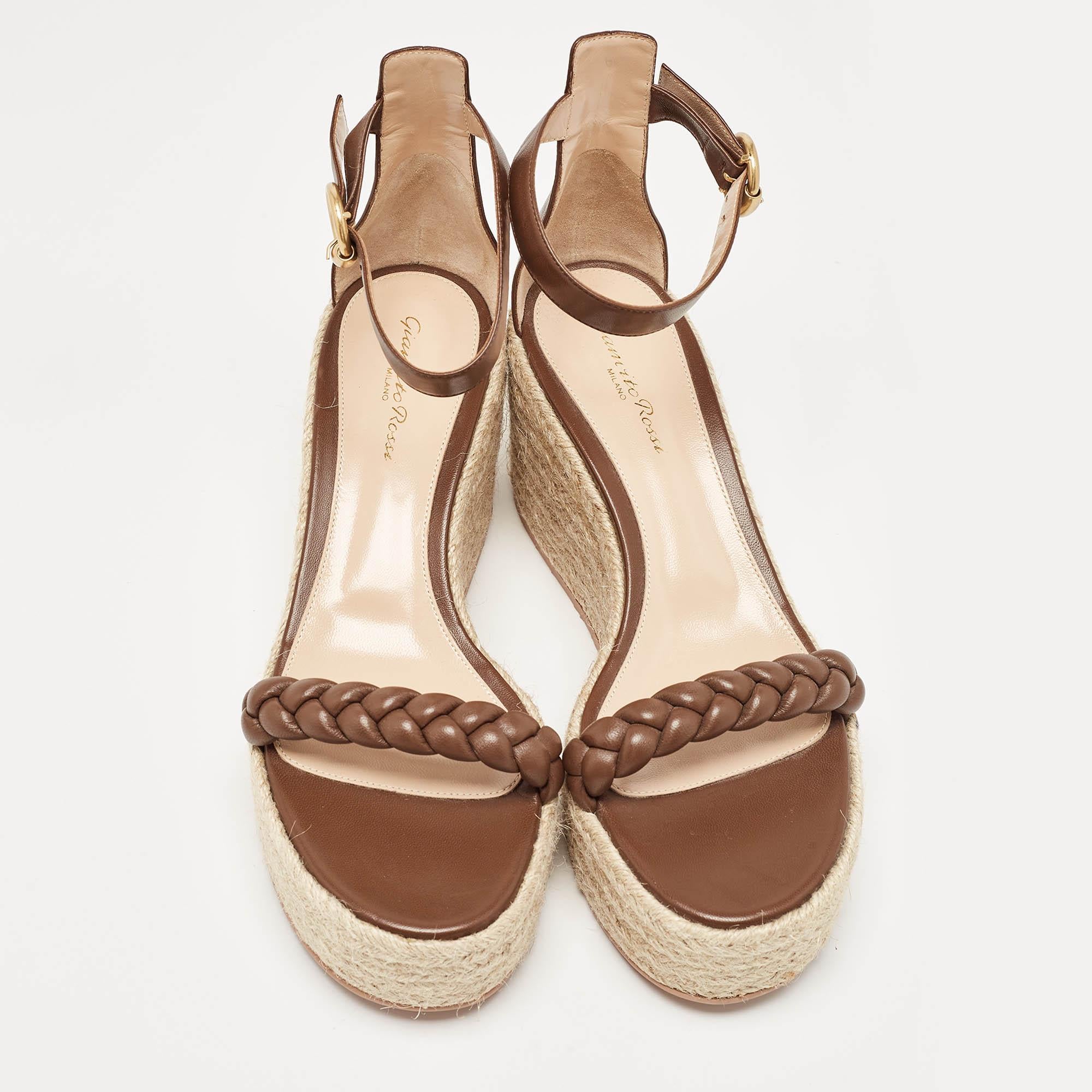 Crafted with meticulous artistry, the Gianvito Rossi Merida sandals epitomize timeless charm. Luxurious brown leather intertwines gracefully, forming intricate braids that exude sophistication. Elevated on a sturdy wedge heel, they seamlessly marry