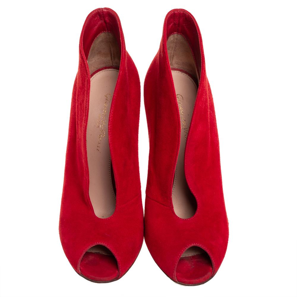 These glamorous booties from Gianvito Rossi are chic and worth admiring! They have been crafted from striking red-hued suede and styled with peep-toes and curved open vamps. They come equipped with comfortable leather-lined insoles and stand tall on