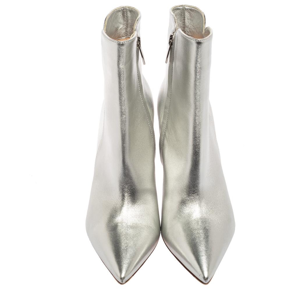 These boots from the House of Gianvito Rossi define elegance and sophistication. Sleek and stylish, their ankle-length silhouette is enhanced with a silver leather exterior, pointed toes, and pointy heels. They flaunt silver-tone fittings and zipper