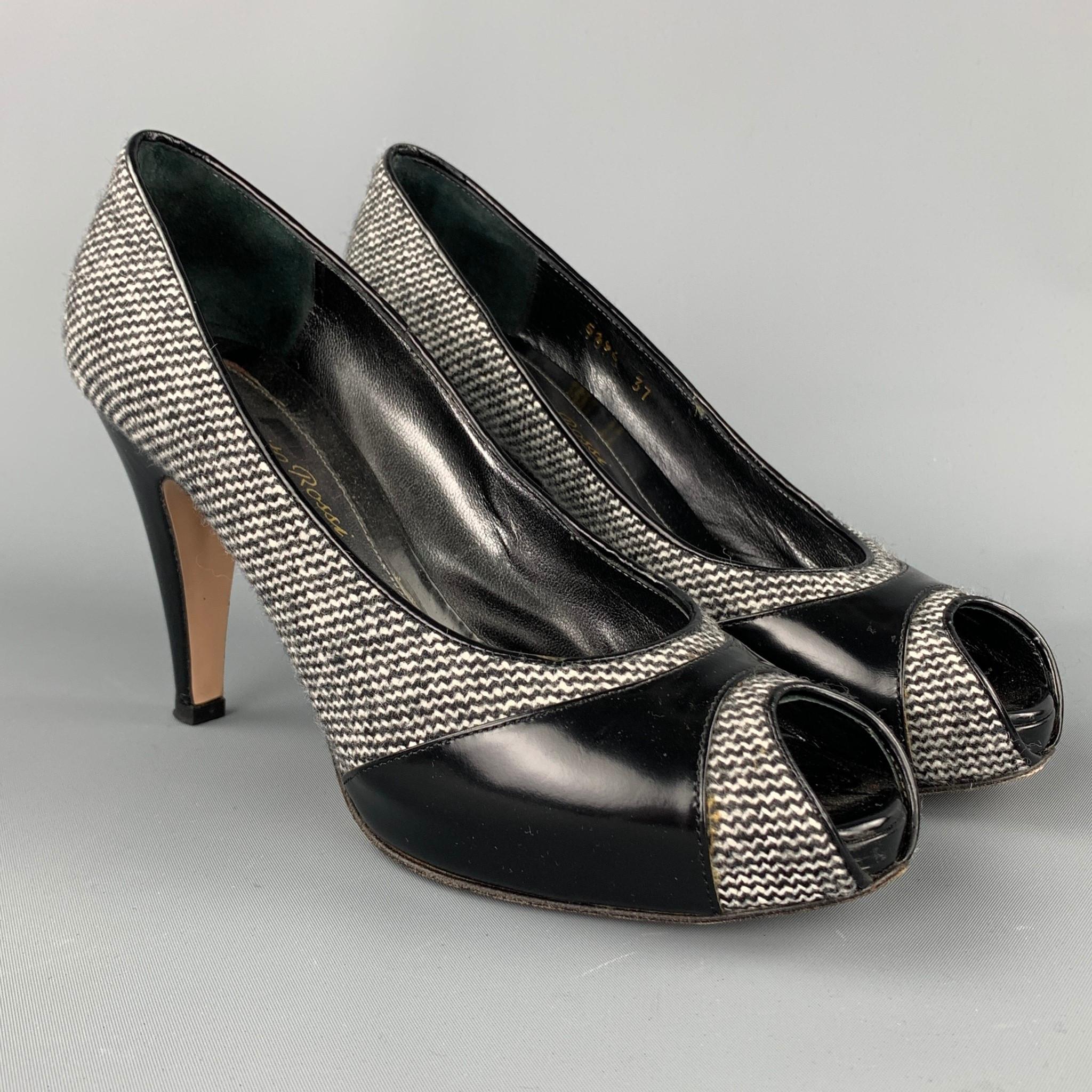 GIANVITO ROSSI pumps comes in a grey tweed with a black patent leather trim featuring a open toe style and a wooden heel. Made in Italy.

Very Good Pre-Owned Condition.
Marked: EU 37

Measurements:

Heel: 4 in.