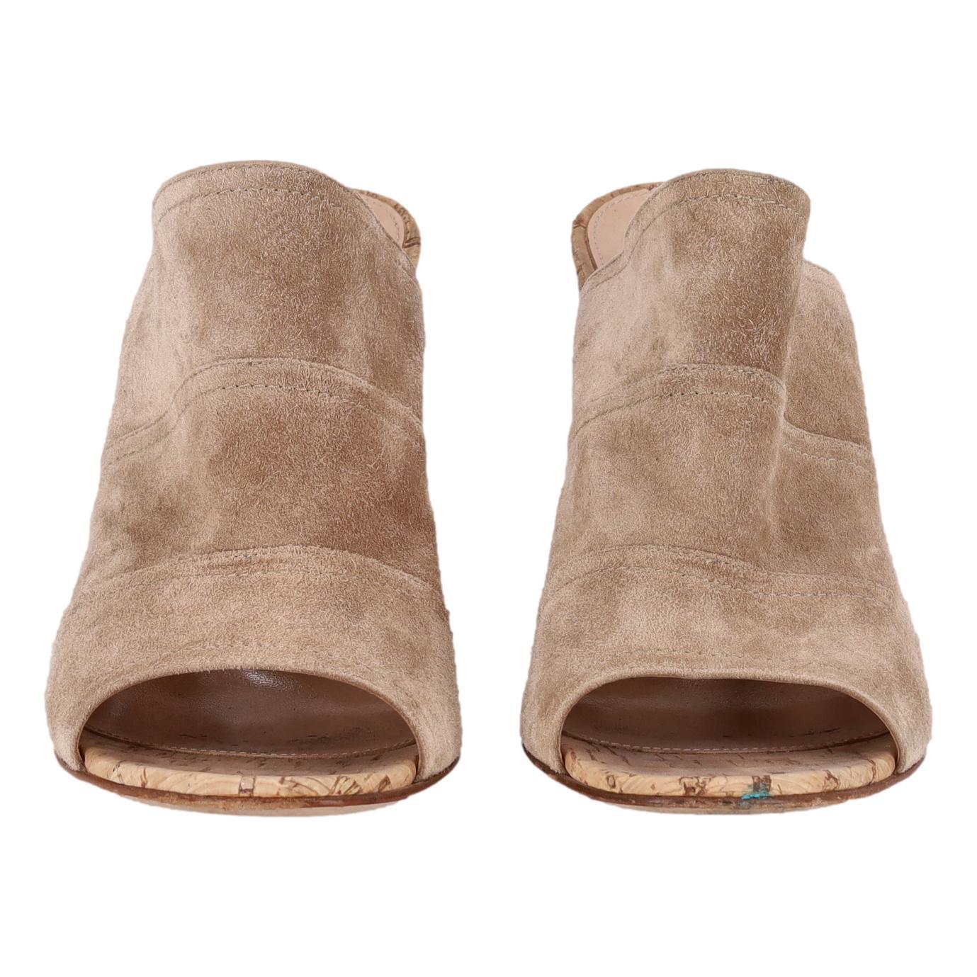 Gianvito Rossi - Mules �à talons en liège et en daim

Mules en daim taupe conçues avec un bout rond ouvert et un haut talon bloc en liège.

Doublure en cuir. Rrp Approx. £590.

Taille - 40

État - Très bon (signes mineurs d'usure)

Composition -