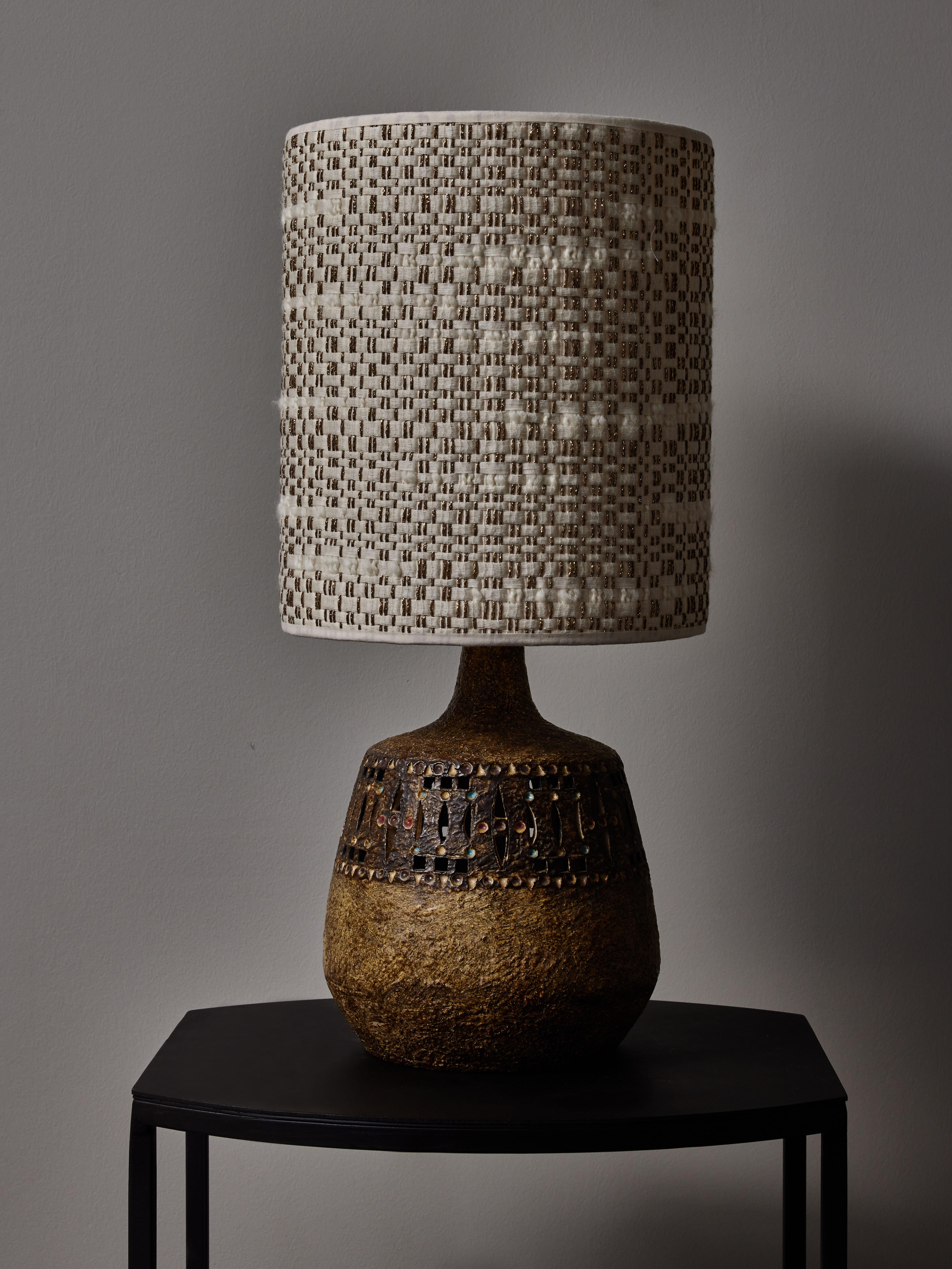 Vintage ceramic table lamp in earth tones with small dots of colours by Raphael Giarrusso in the 1960s. Topped with a new lampshade with Dedar Milano fabric.

Raphaël Giarrusso (1925-1986)
Canadian painter, sculptor and ceramist who established