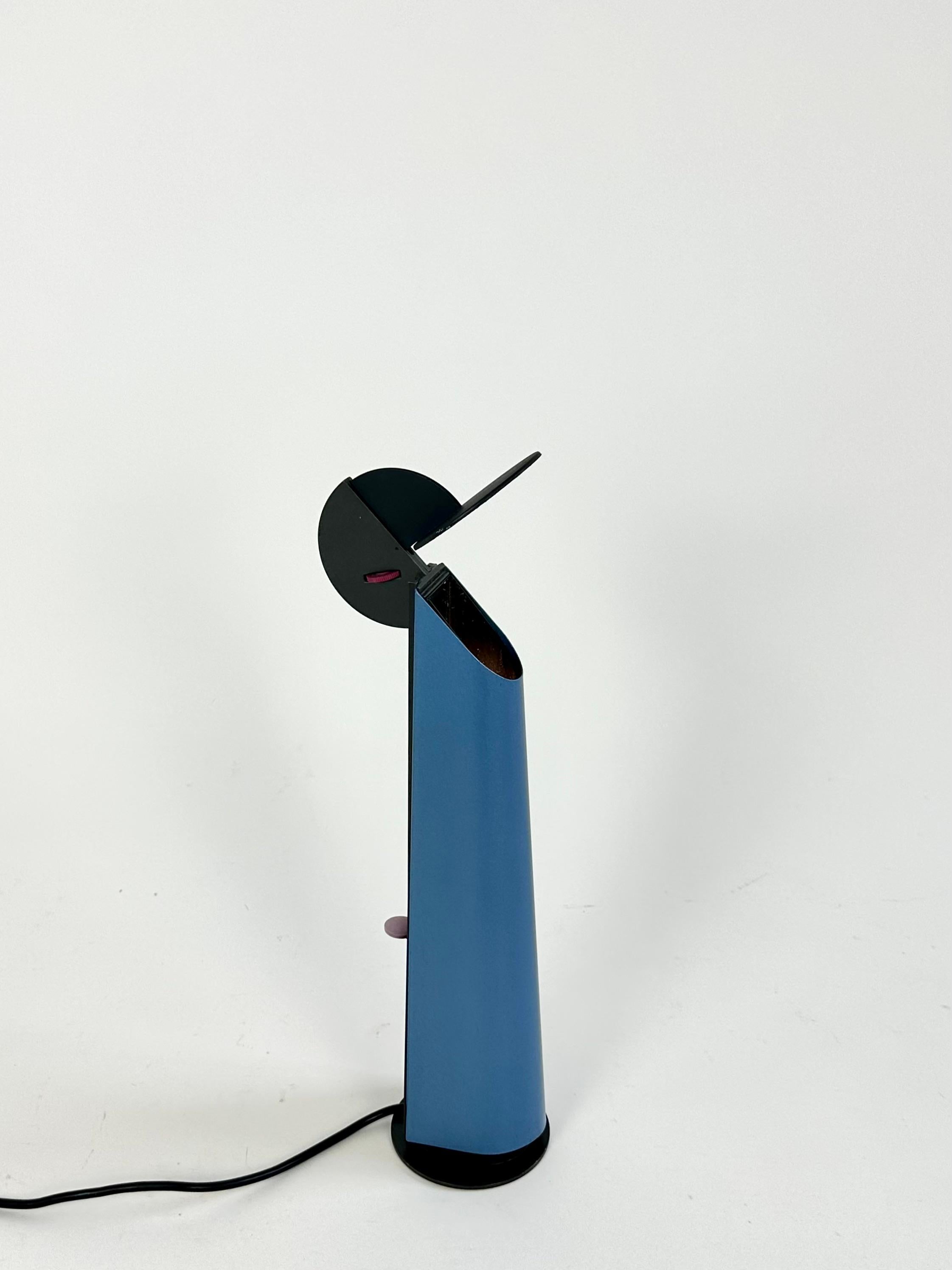 Lampe de table post-moderne Gibigiana conçue en 1980 par Achille Castiglioni pour Flos, Italie.

Un miroir mobile réfléchit la lumière à partir d'une source cachée dans la lampe. L'intensité lumineuse est réglée par un variateur situé à l'arrière de
