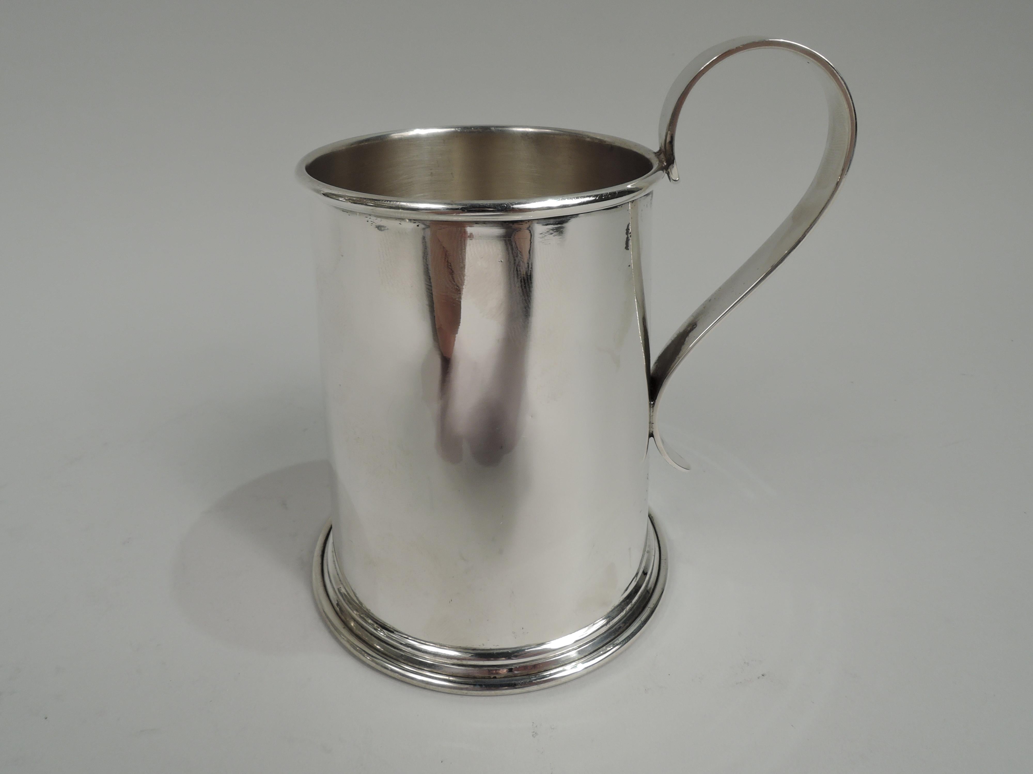 Midcentury sterling silver trophy mug. Straight and upward tapering sides, spread base, and high-looping handle. On front is engraved “Gibson Island / Poplar Island / 1953 / Racing Division / First / Hurrying Angel”. Above is applied enamel burgee