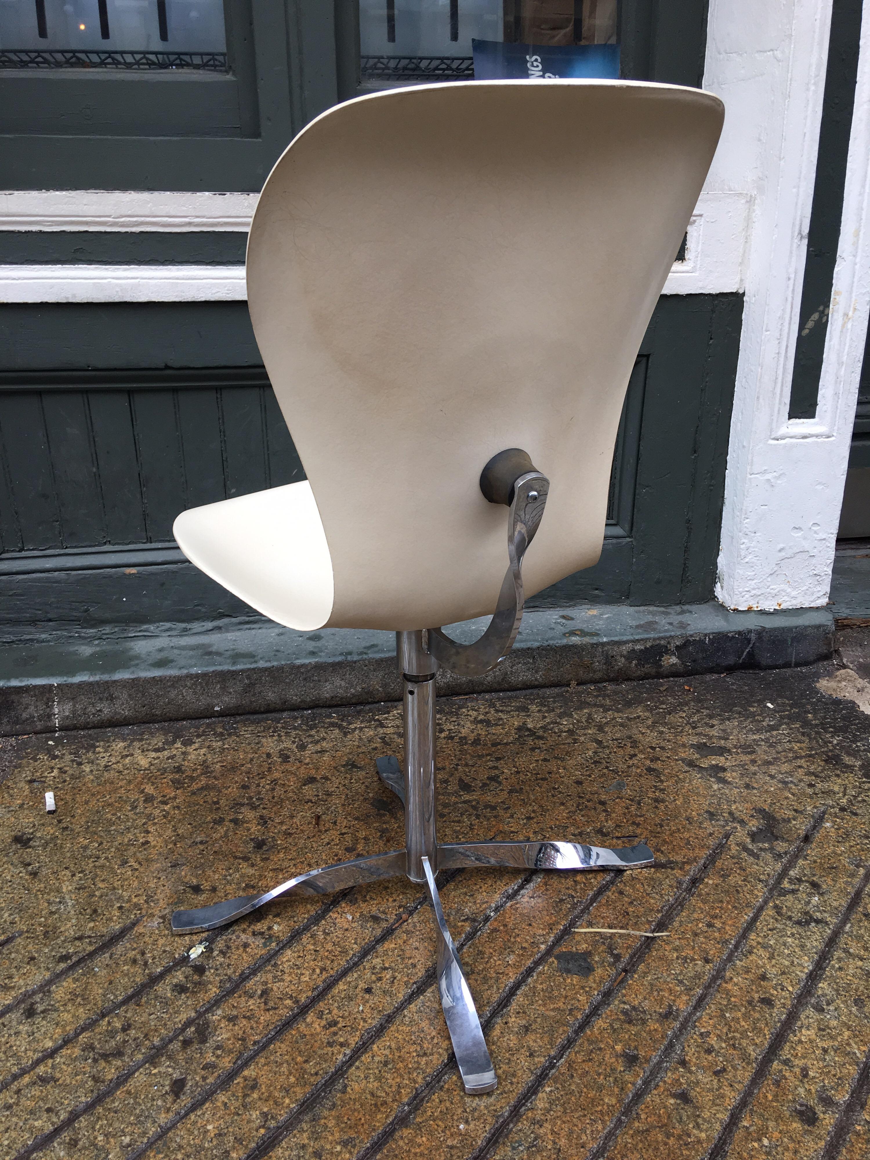 Gideon Kramer ion chair with white fiberglass shell and chrome supports. This chair swivels and flexes with the rubber bushings connecting it to the steel frame. Remnants of a blue decal label remain. Chairs was designed and first made in 1962 in