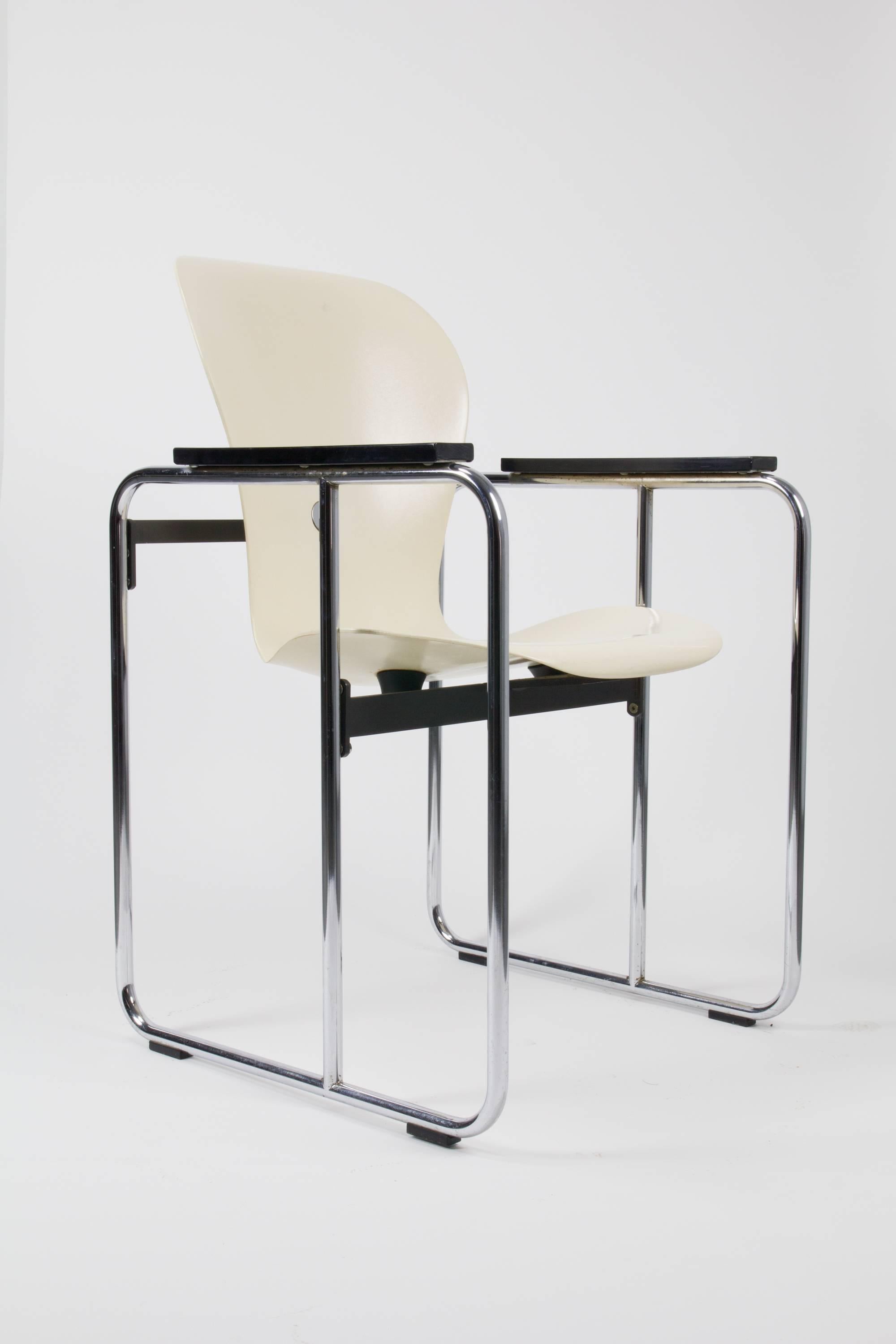 Uncommon variant of the Ion chair by Gideon Kramer, with molded fiberglass seat suspended in a tubular steel cage-frame, black painted wood armrests and rubber shock mounts. Retains original label.