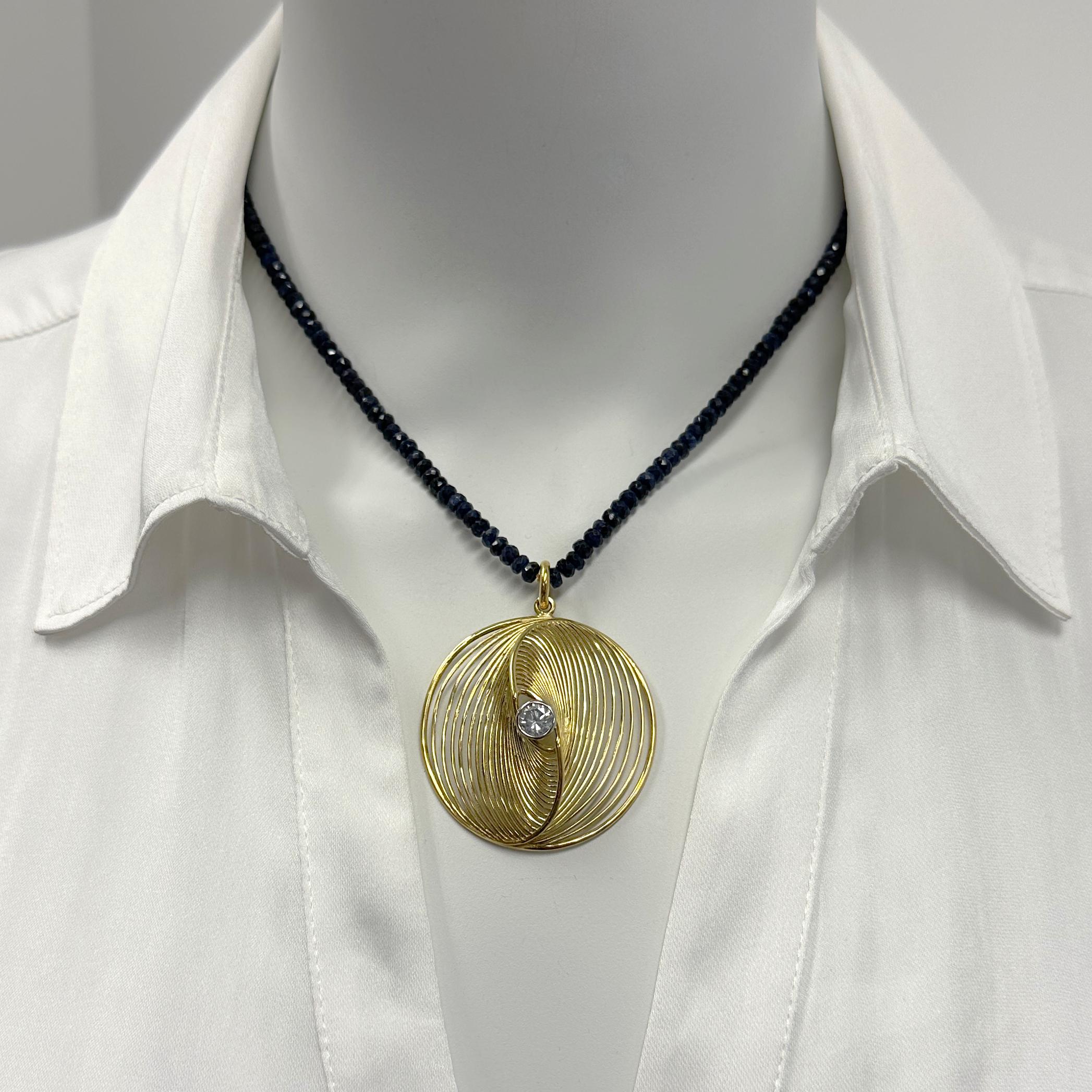 This bold and graphic new pendant by Eytan Brandes is based on a design suggested by Eytan's brother Gidi, an artist living in Israel.  Like a swirling yin and yang symbol, waves of rich 18 karat yellow gold wire curve gracefully into a middle --