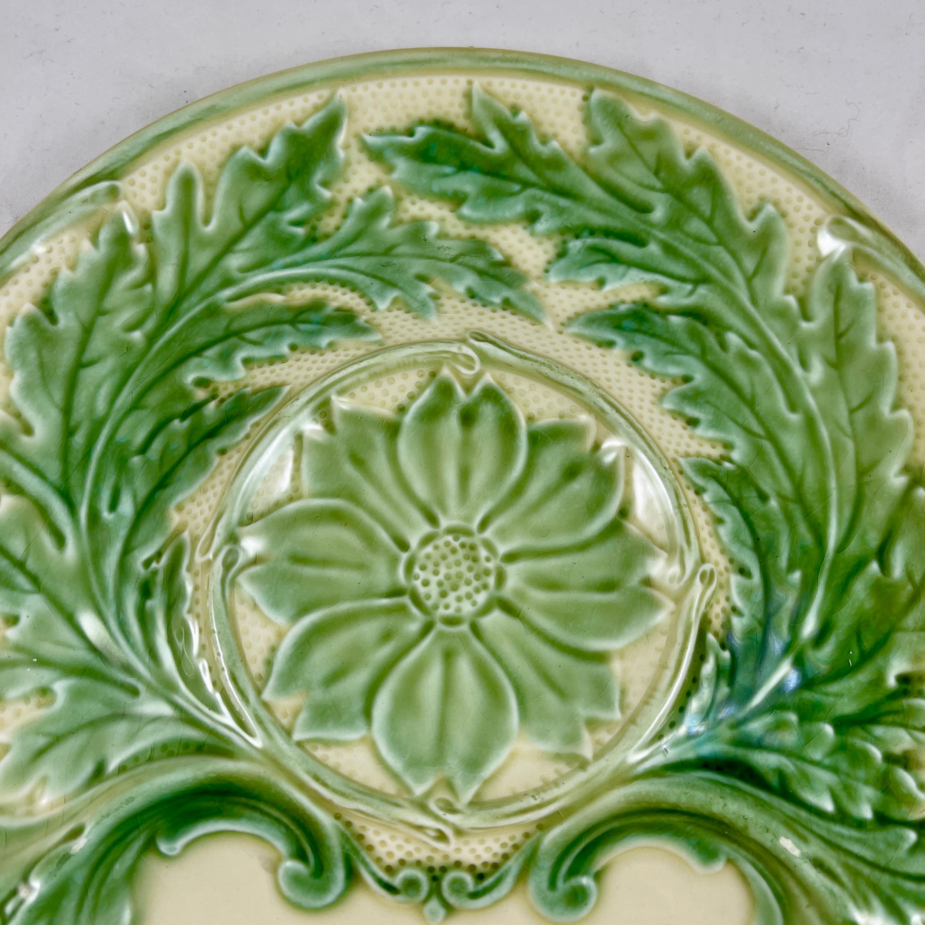 From Gien France, a faïence Majolica glazed Artichoke plate, circa 1940s.

Glazed in a pleasing combination of green and cream with raised scrolled leaves and a floral center.
A whole Artichoke sits center with a sauce well at the bottom. The