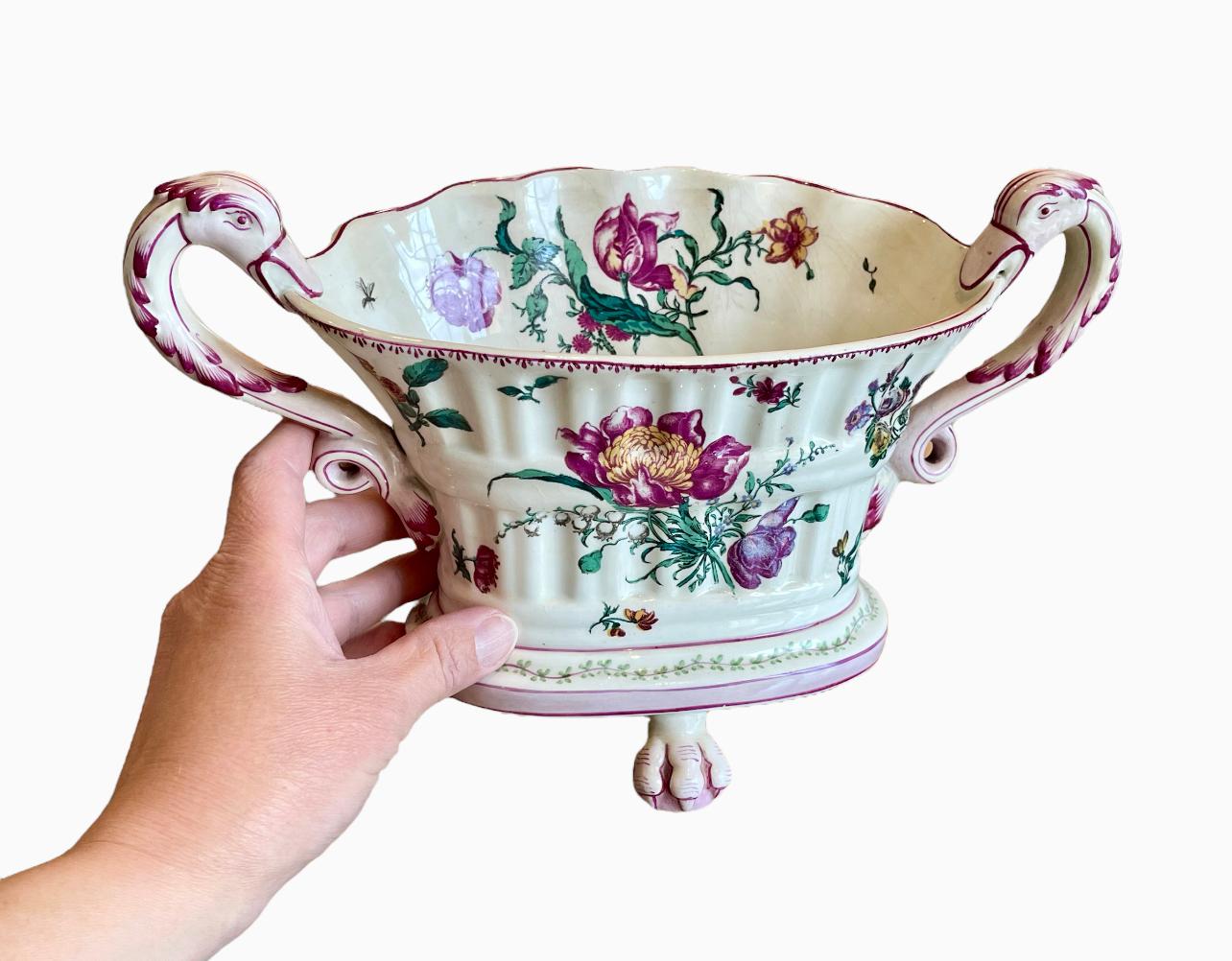 Lovely little Gien earthenware planter or planter with floral decoration. Dominant purple and green colors on an ecru background. On either side, swan neck shaped handles. It rests on three claw feet and has the Gien factory mark underneath. It is