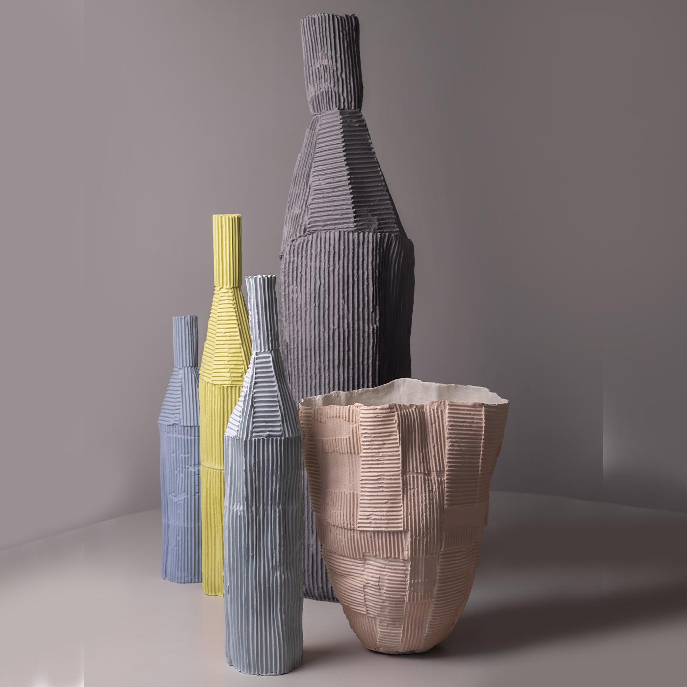 Cette bouteille décorative présente une silhouette élégante et haute avec une texture nervurée distinctive qui ajoute de la profondeur et de l'intérêt. Fabriqué à partir d'un composite unique d'argile papier, il offre des variations tactiles qui