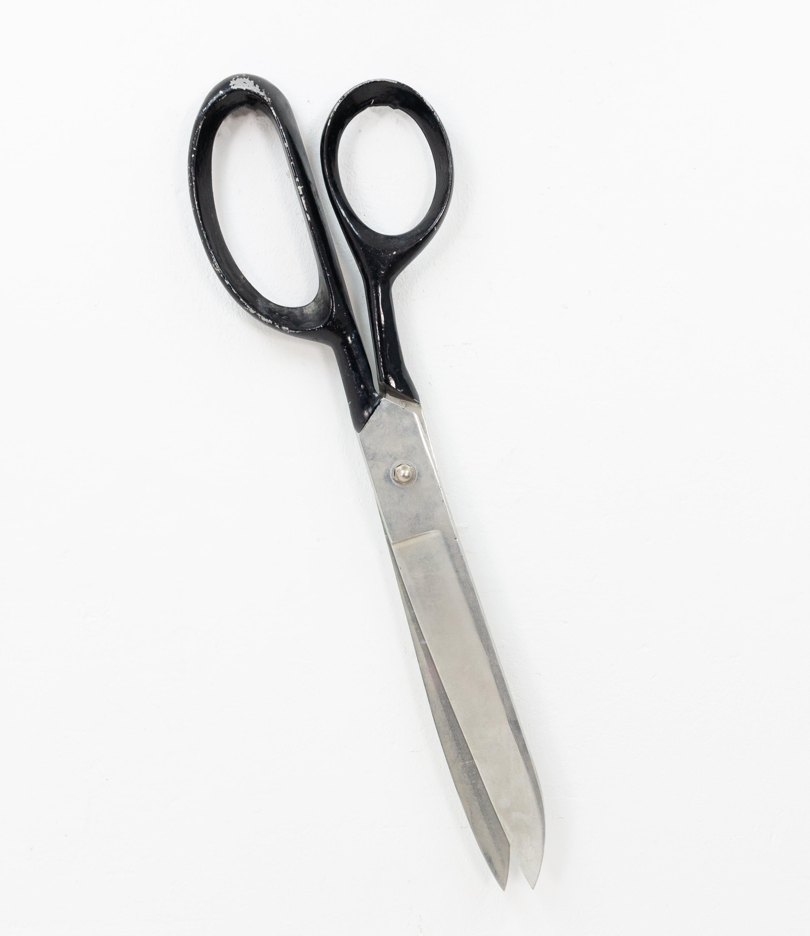 Gigantic scissor. Used for advertising. In a clothing re-pare store. In the Haque, Holland
From the 1970s .Made off aluminium. Hanging outside off the golden scissor. Clothing re pare store.
   