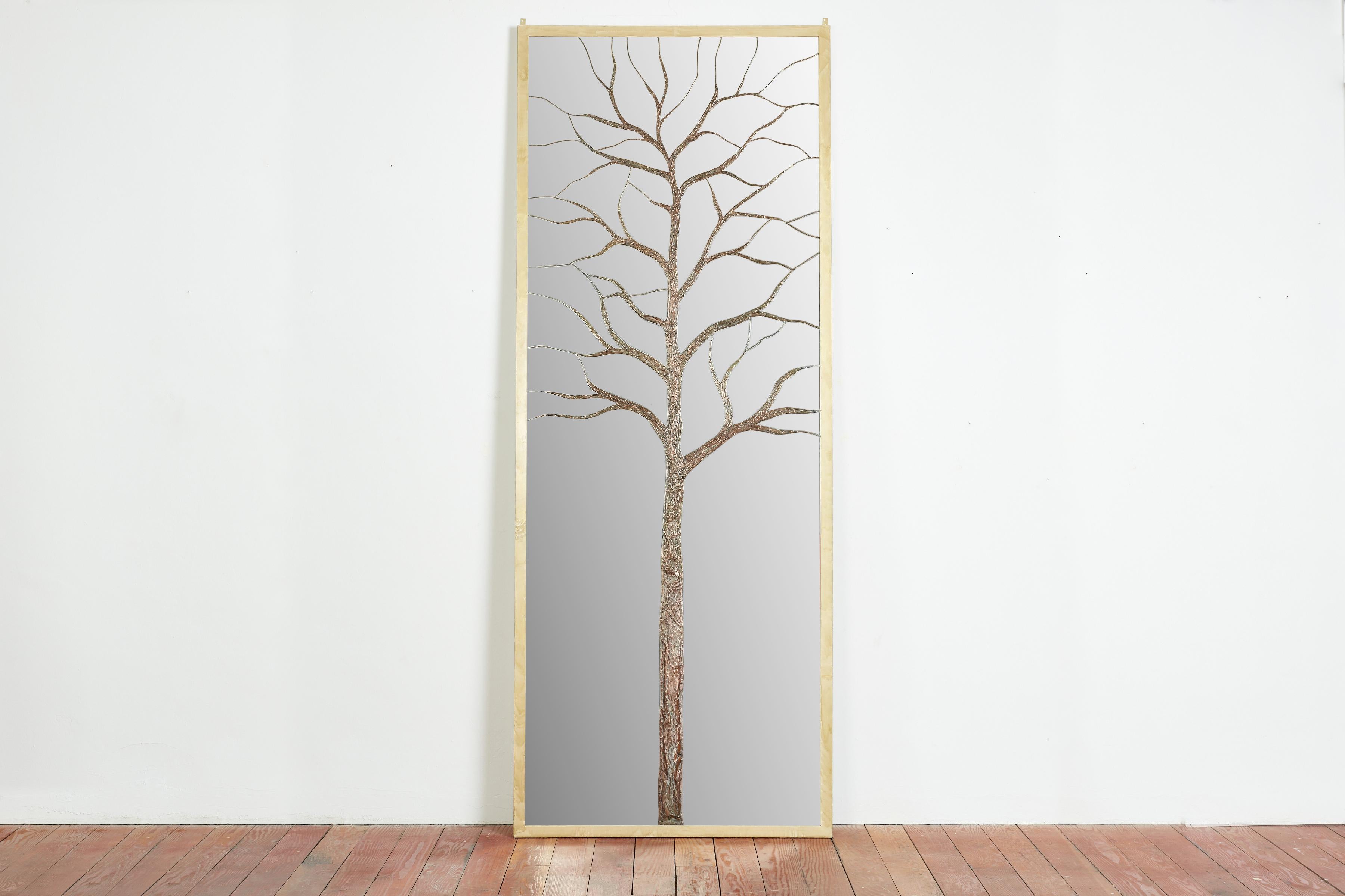 Miroir gigantesque sur pied avec un arbre en bronze et cuivre repoussé qui a été sculpté dans le miroir. 
Une œuvre d'art d'une grande beauté 
Cadre métallique en laiton doré - 
Signature sur le miroir - 
Italie, 1965 
Unique en son genre

