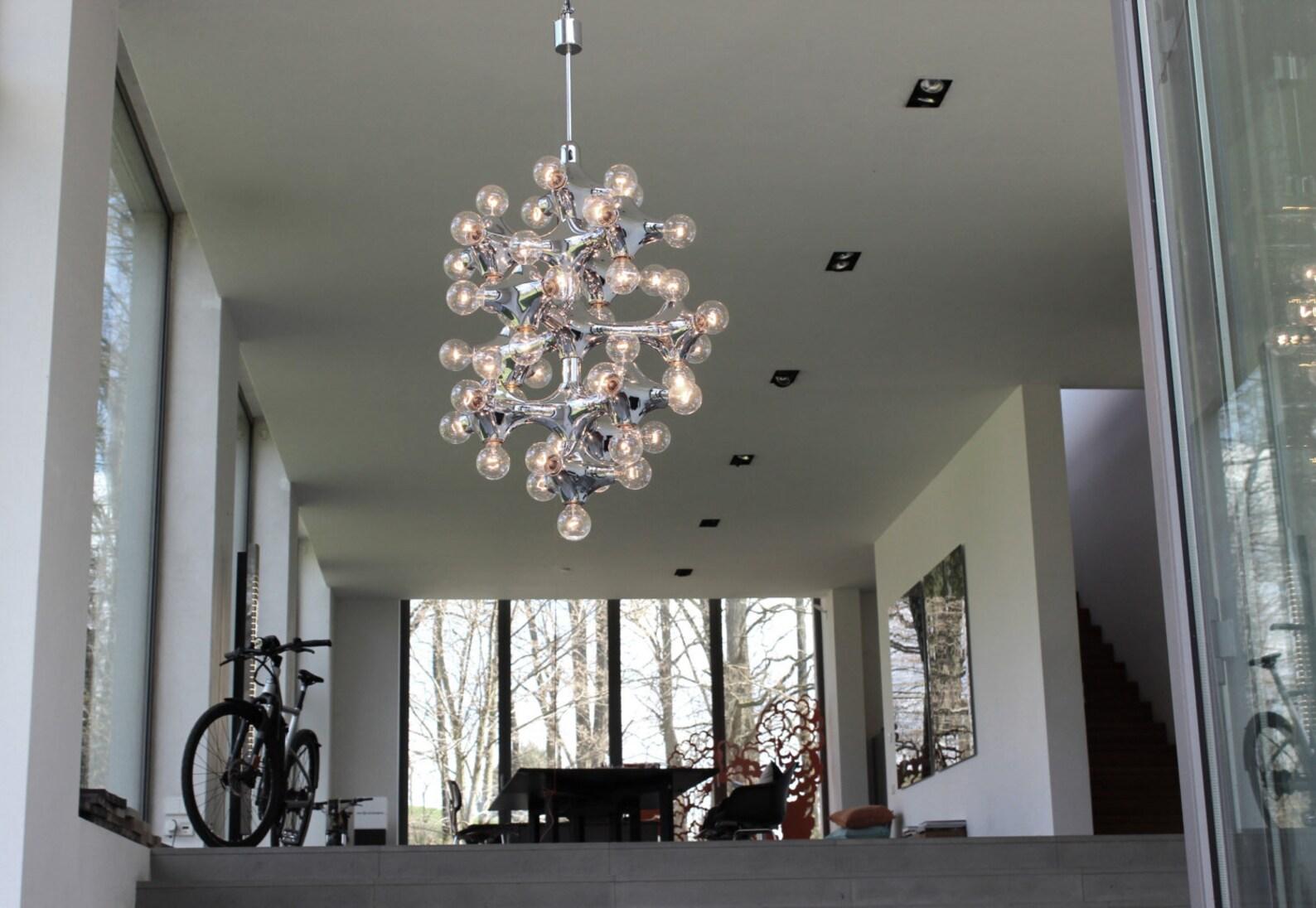DIAMETER 2,6 FEET / HEIGHT OF THE BODY 3,3 FEET/ TOTAL HEIGHT 4,5 FEET

MONUMENTAL 43 LIGHTS (E27) GERMAN ORGANIC MOLECULES CHANDELIER MIRRORED 1960s-1970s

Exceptional architecture need special solutions for lighting! This extraordinary