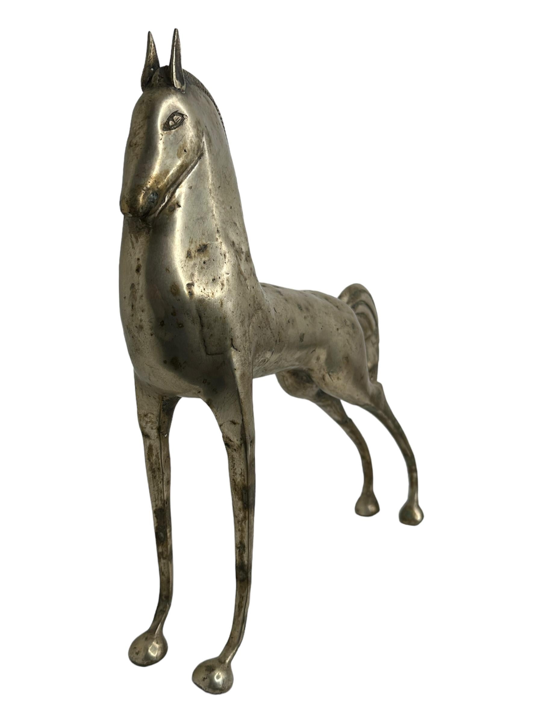 This is a nickel plated metal sculpture, in the style of the antique statues and figures of the Etruscans. It is a gorgeous interior furnishing item, an incredibly stylized Horse and has a patina finish. probably Italian-made and great for any