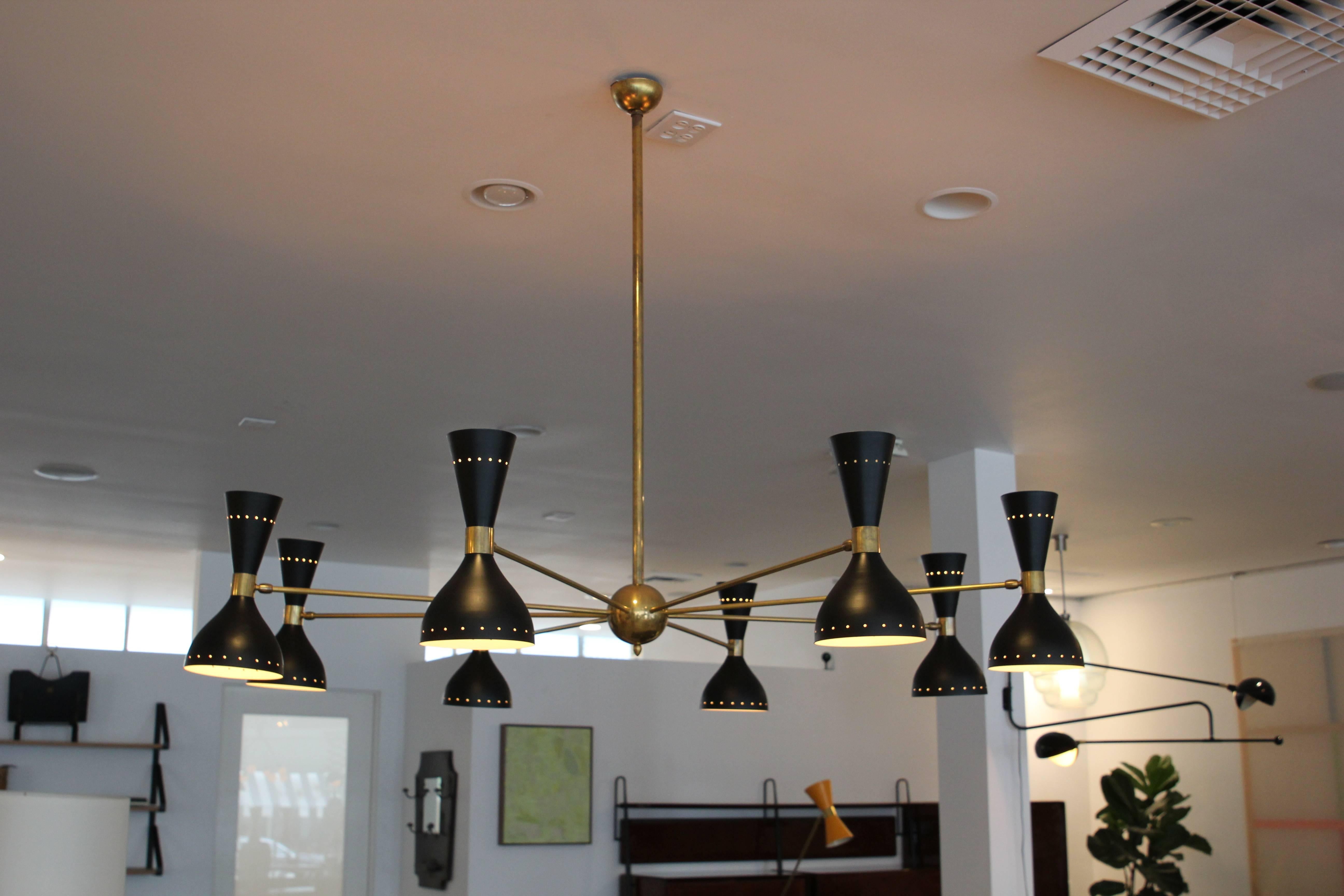 Gigantic ceiling light in 1950s Italian Stilnovo style. Large-scale brass and black metal shades, with eight articulating lampshades which light upward and down. 
Incredibly crafted in Italy.