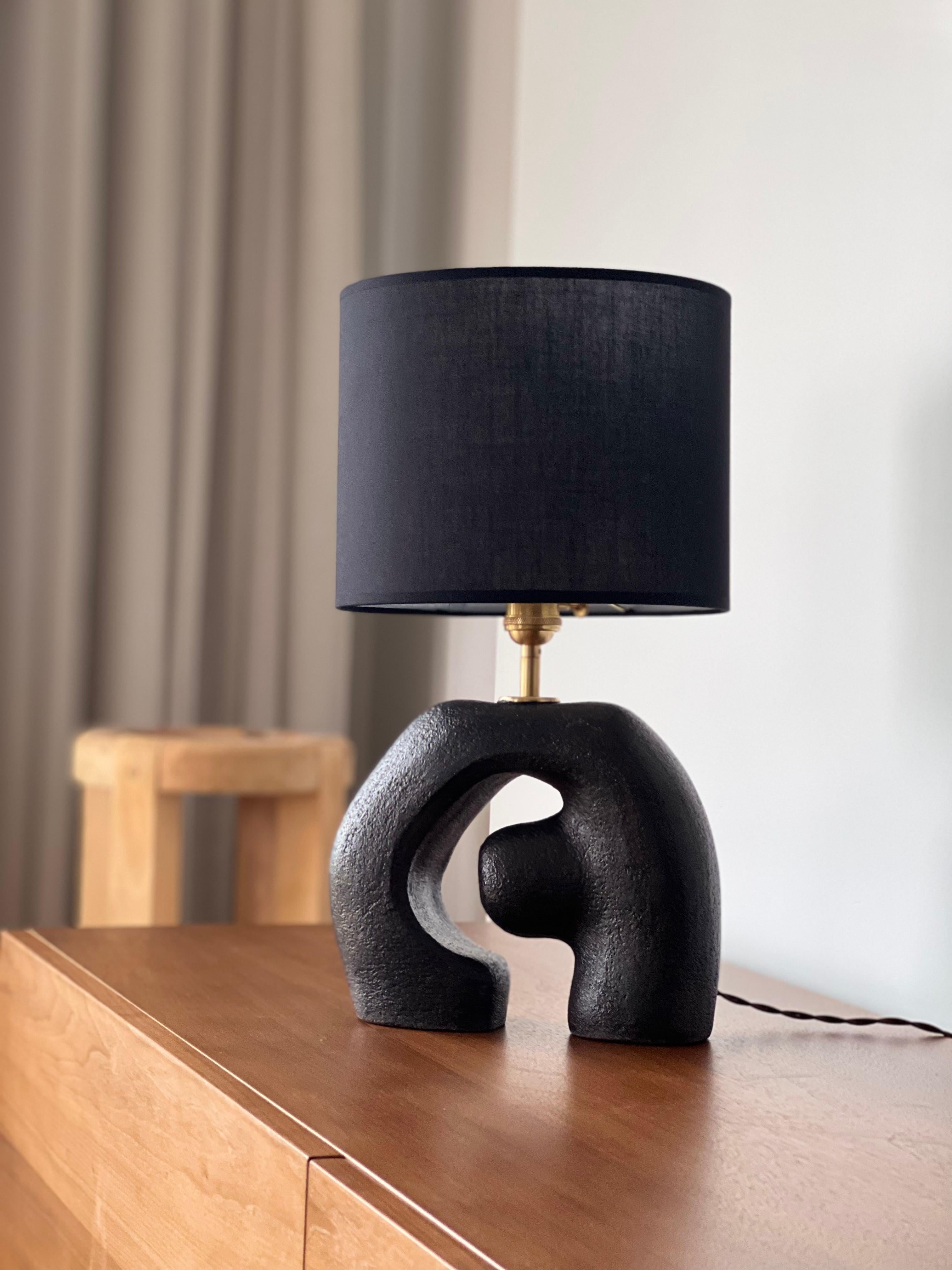 Gigi Black Lampshade by Güler Elçi
Dimensions: W 25.4 x D 12.7 x H 47 cm.
Materials: Stoneware Ceramic, Linen, Unfinished Brass.

Güler Elçi is a ceramic artist based in Istanbul. In the light of her engineering career, she considers ceramics as a