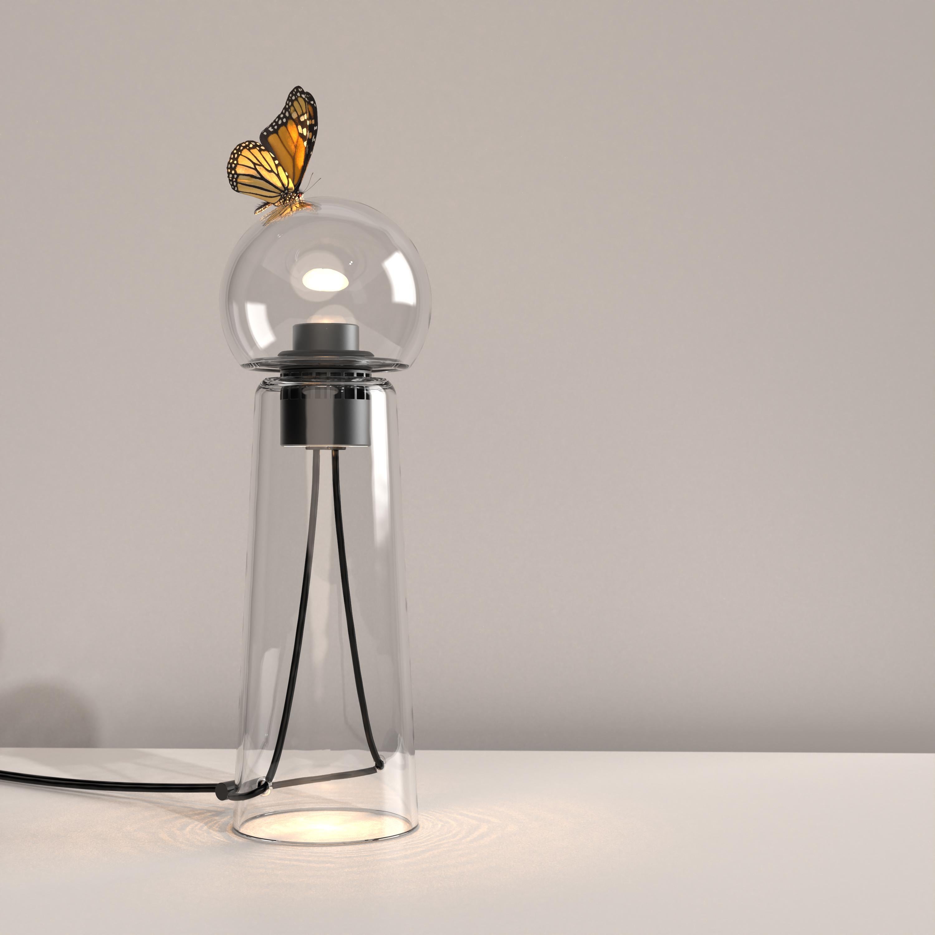 Gigi clear is a contemporary LED table lamp made of handcrafted blown glass.

Gigi is playful. Its lines are daring and its tones sensual. Under the breath of the glassblower, the unique shades and tones of the colour spread throughout the