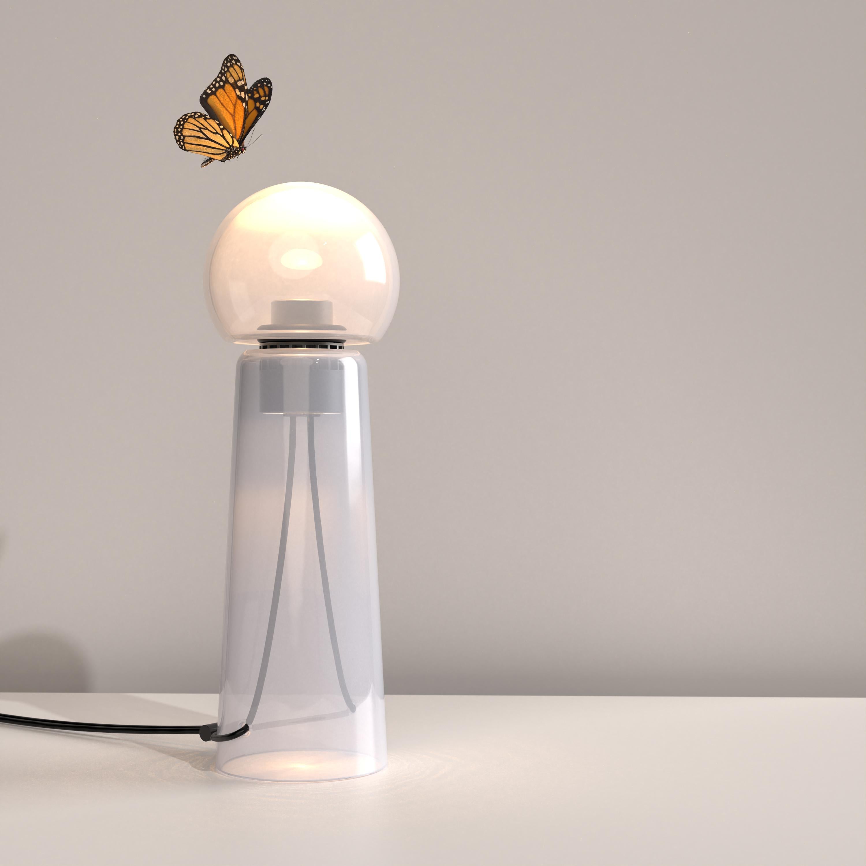Gigi Fog (translucent white) is a contemporary LED table lamp made of handcrafted blown glass.

Gigi is playful. Its lines are daring and its tones sensual. Under the breath of the glassblower, the unique shades and tones of the colour spread
