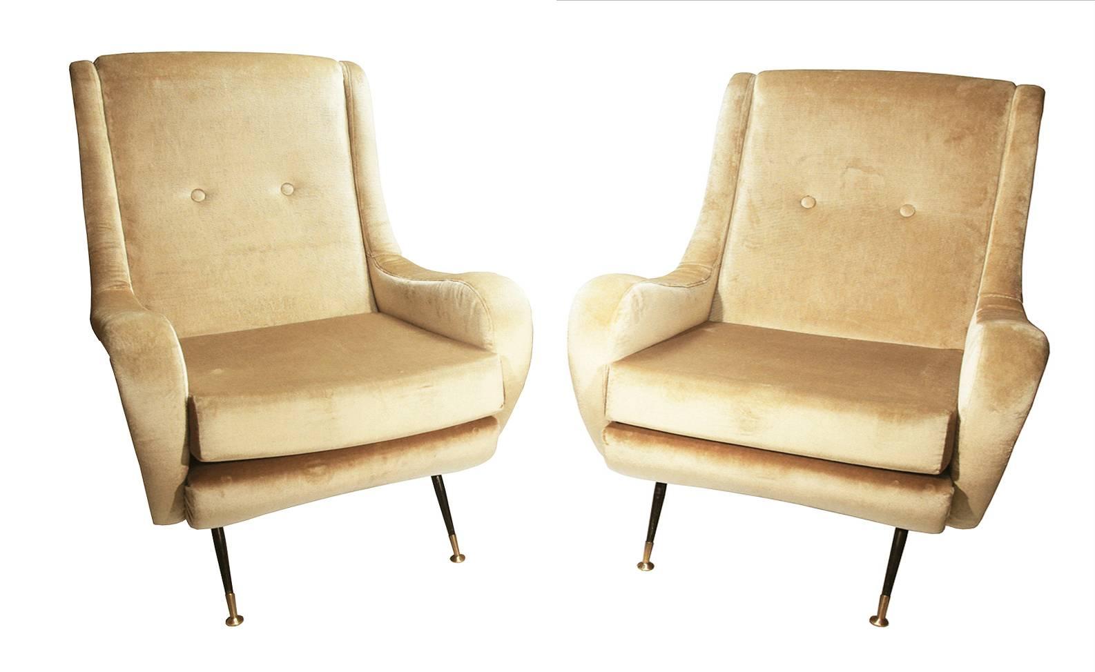 An elegant pair of Gigi Radice armchairs reupholstered in a luxurious champagne colored velvet, ebonized tapered legs ending in bronze caps.