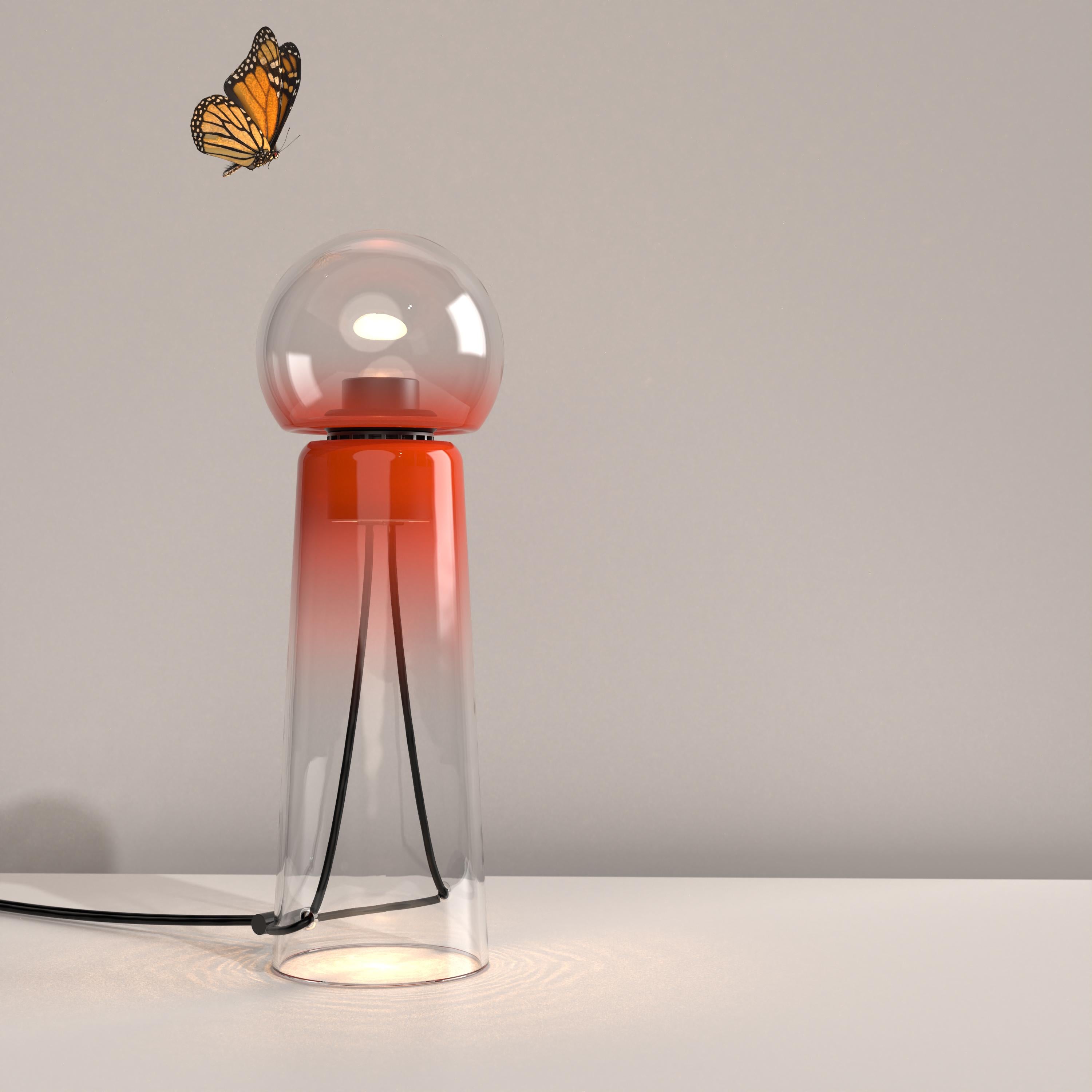 Gigi red is a contemporary LED table lamp made of handcrafted blown glass.

Gigi is playful. Its lines are daring and its tones sensual. Under the breath of the glassblower, the unique shades and tones of the colour spread throughout the material.