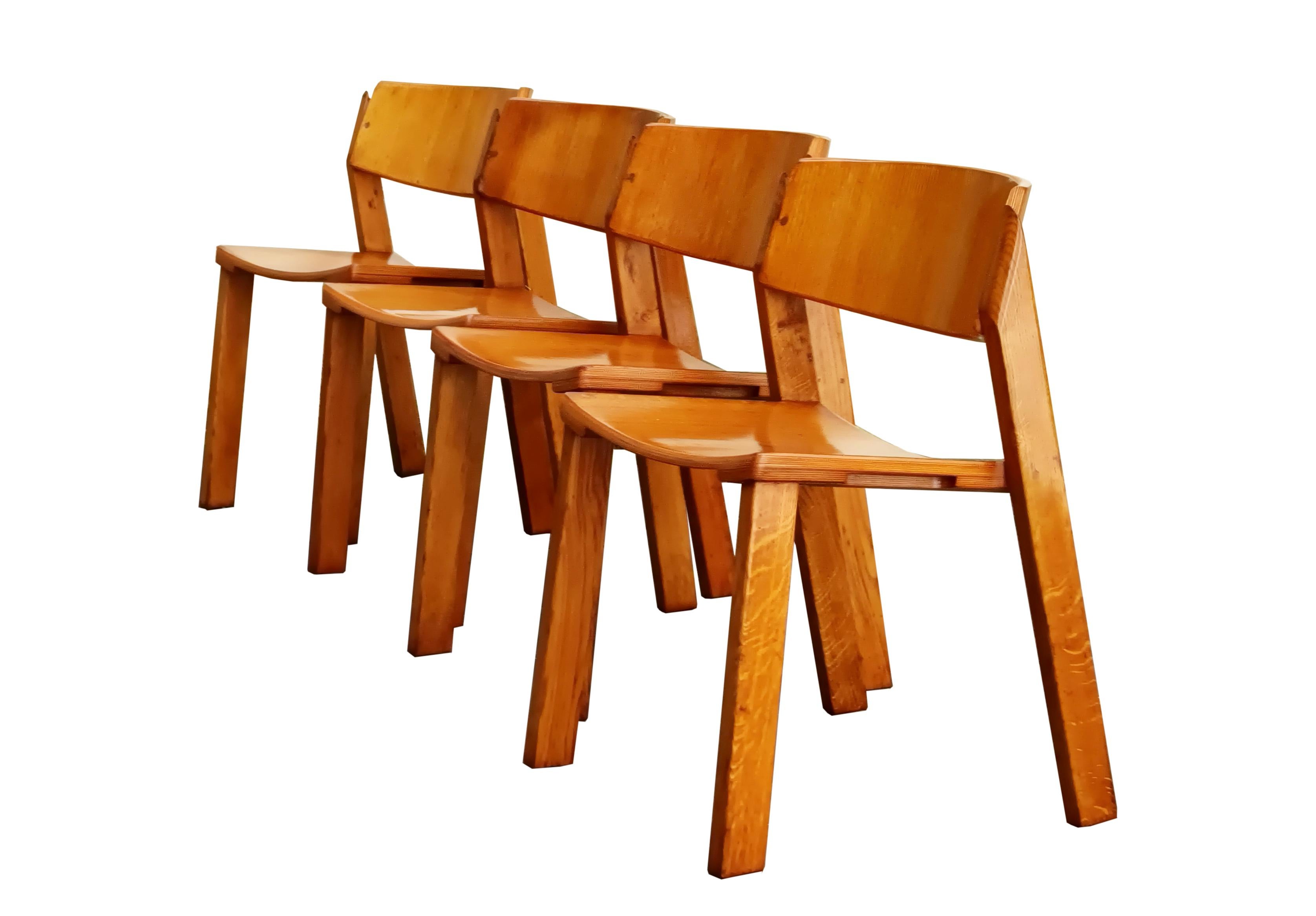 Juego de cuatro sillas de madera apilables con patas cuadradas y respaldo curvado e inclinado.