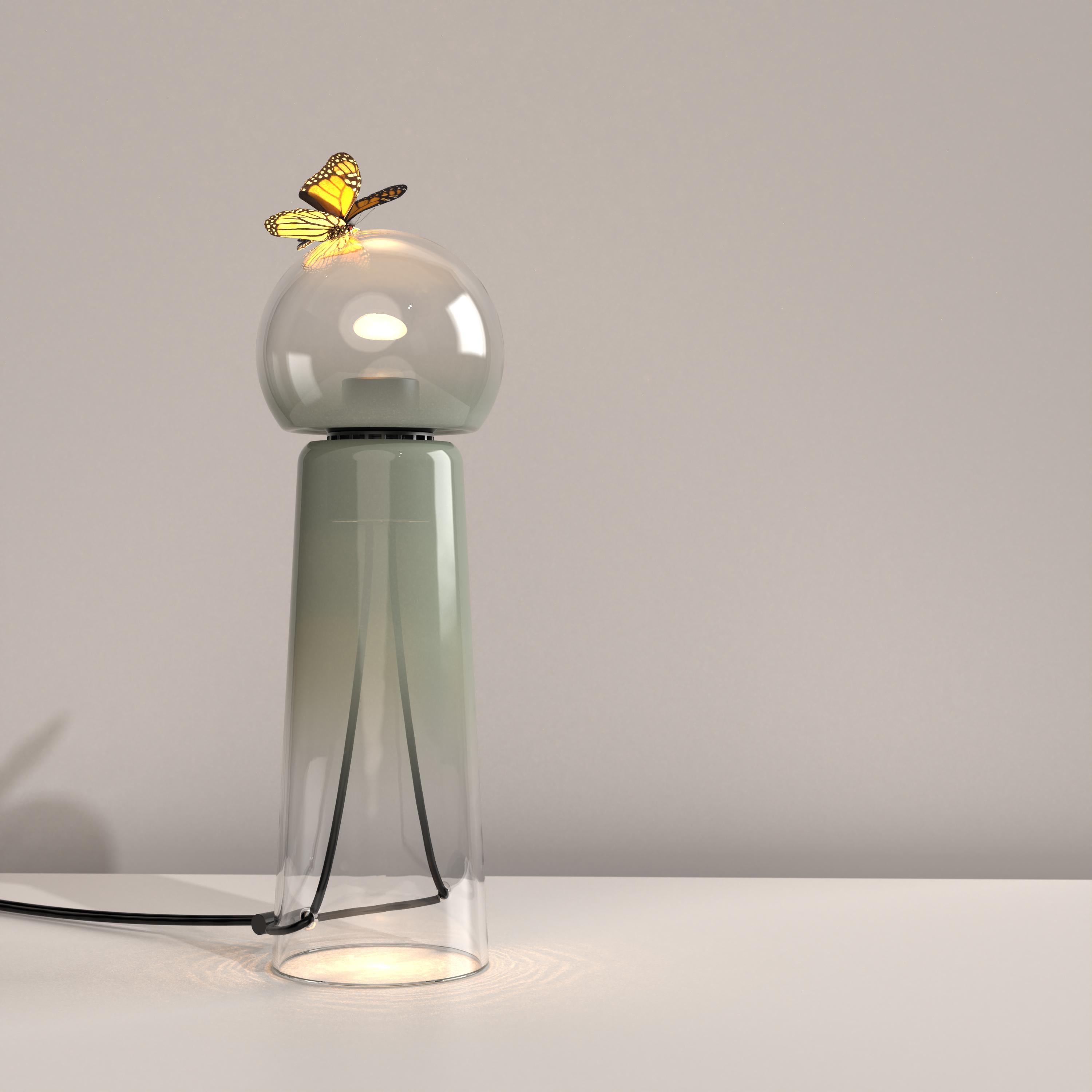 Gigi Sage (light green) is a contemporary LED table lamp made of handcrafted blown glass.

Gigi is playful. Its lines are daring and its tones sensual. Under the breath of the glassblower, the unique shades and tones of the colour spread