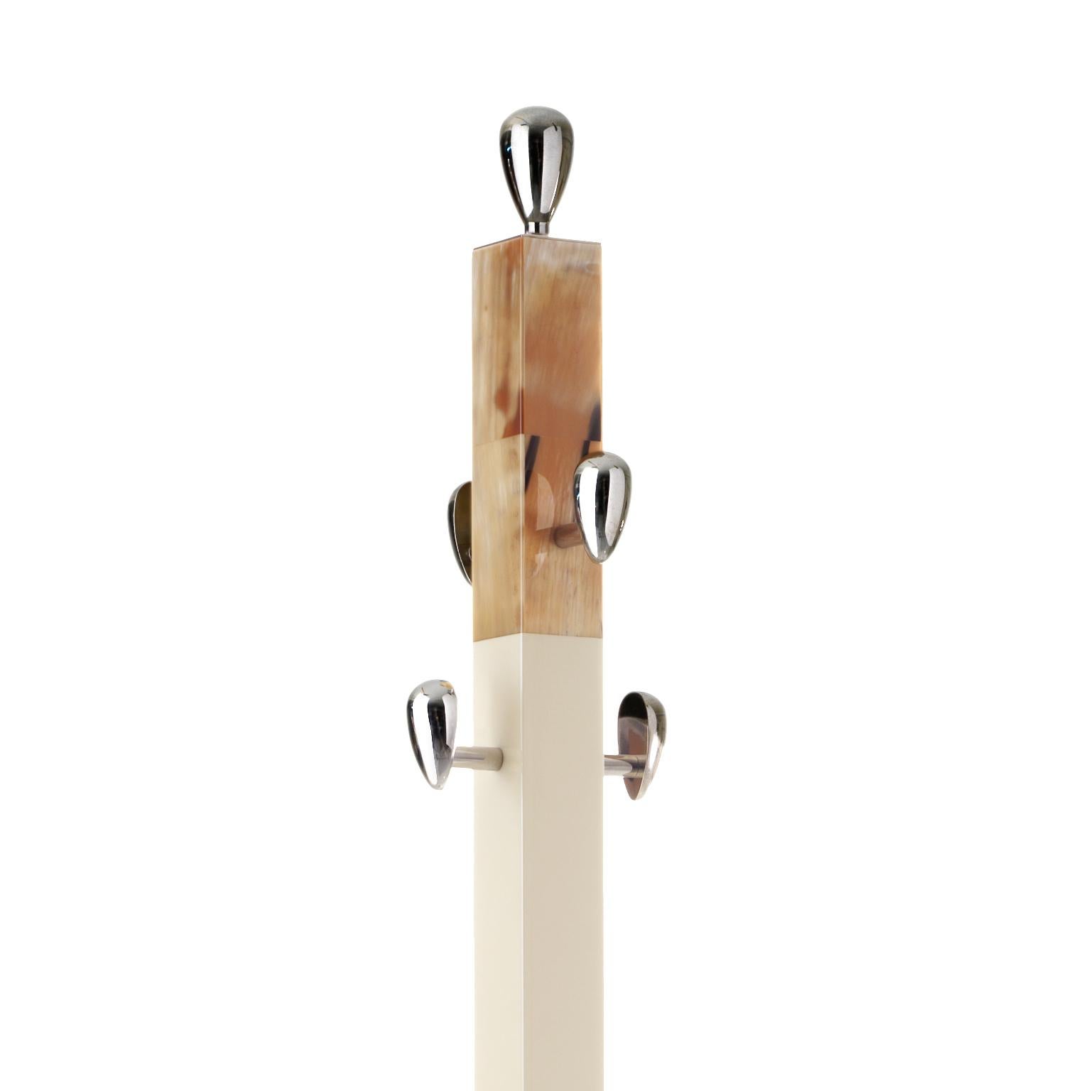 The Giglio coat stand is a functional decorative statement. With a slim cream-colored stem standing atop a wide base in chromed brass, this coat stand is adorned with inlays in Corno Italiano which add an opulent touch to the wooden structure.