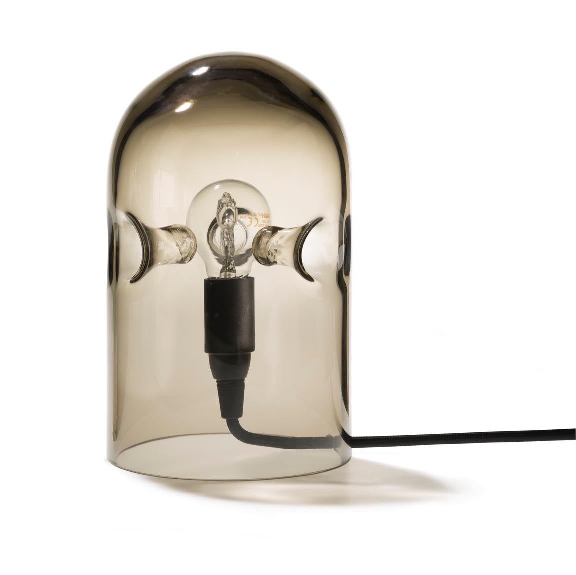 Table lamp designed by Gijs Bakker in 1988. 

The tripod is a sensual table lamp made of one piece of moth-blown glass. Three intriguing structures support the light bulb in the centre of the lamp. All Tripods are mouth-blown and therefore