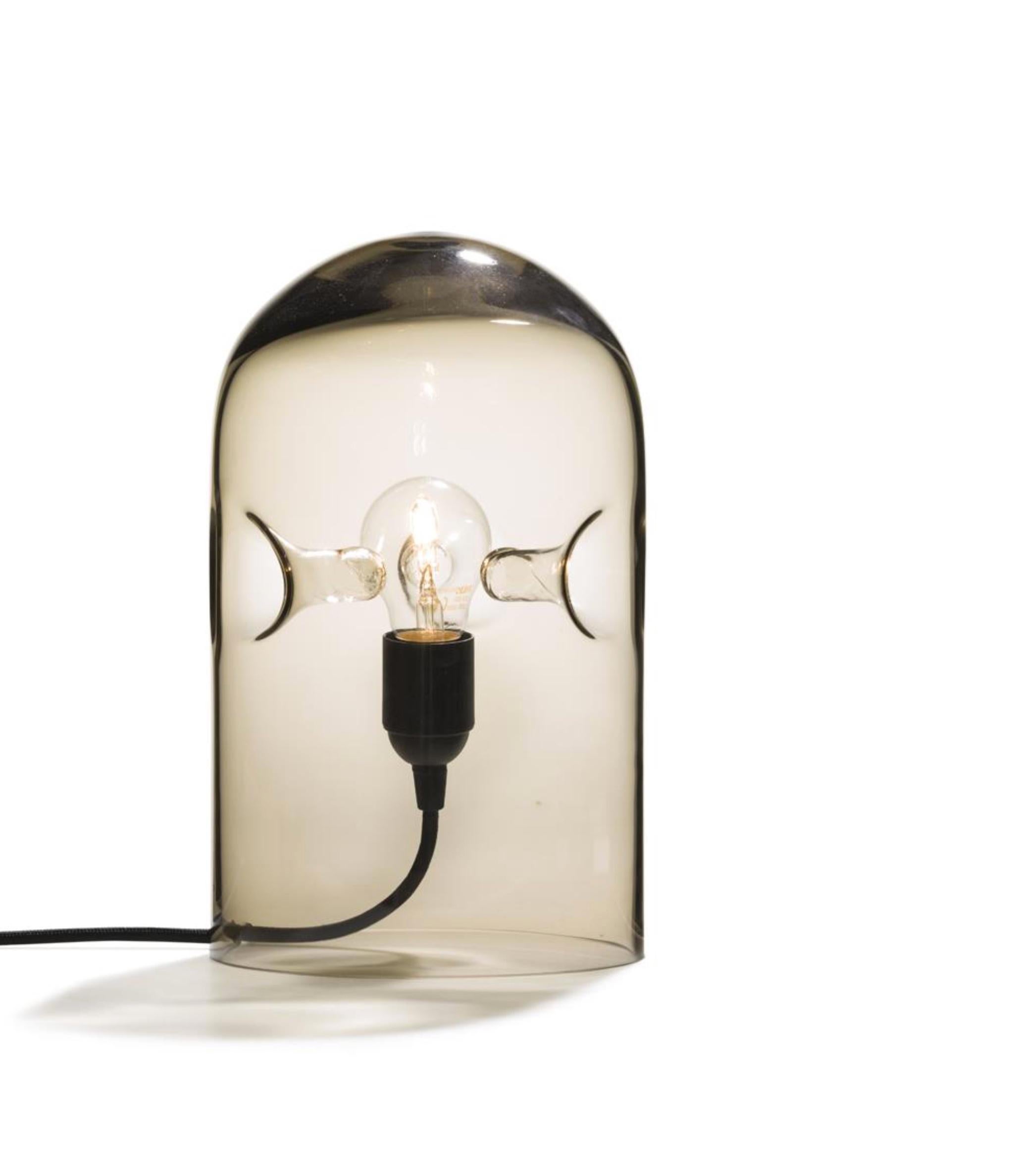 The 'Tripod' lamp by Gijs Bakker, designed in 1978, is a sensual table lamp made of one piece of moth-blown glass. Three intriguing structures support the bulb in the centre of the lamp. All Tripods are mouth-blown and therefore unique.