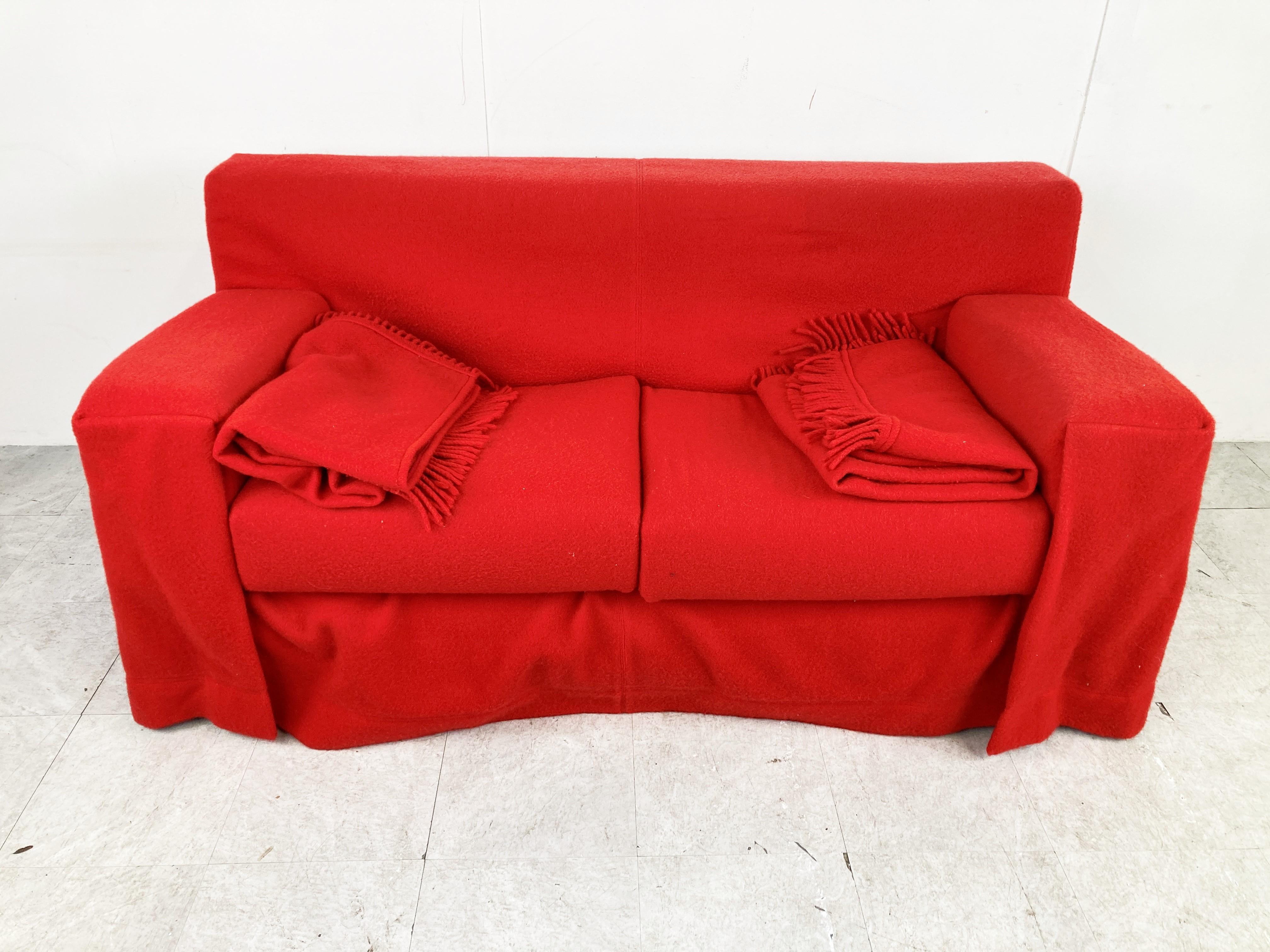 Contemporary design 'Gli Abiti' sofa designed by Ferré and Paolo Nava for B and B Italia.

Beautiful red fabric with the matching blankets.

This sofa was created when when Piero Busnelli, founder of B&B Italia commissioned a fashion designer,