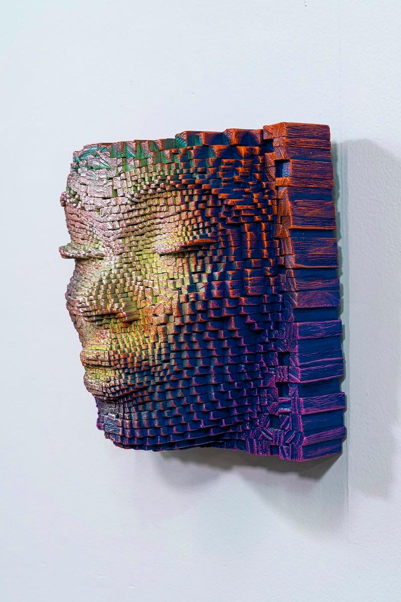 This remarkably innovative work features a face sculpted in relief from blocks of colored wood, creating a striking three-dimensional effect. Each block appears meticulously positioned to capture the contours and expressions of the face, evoking a