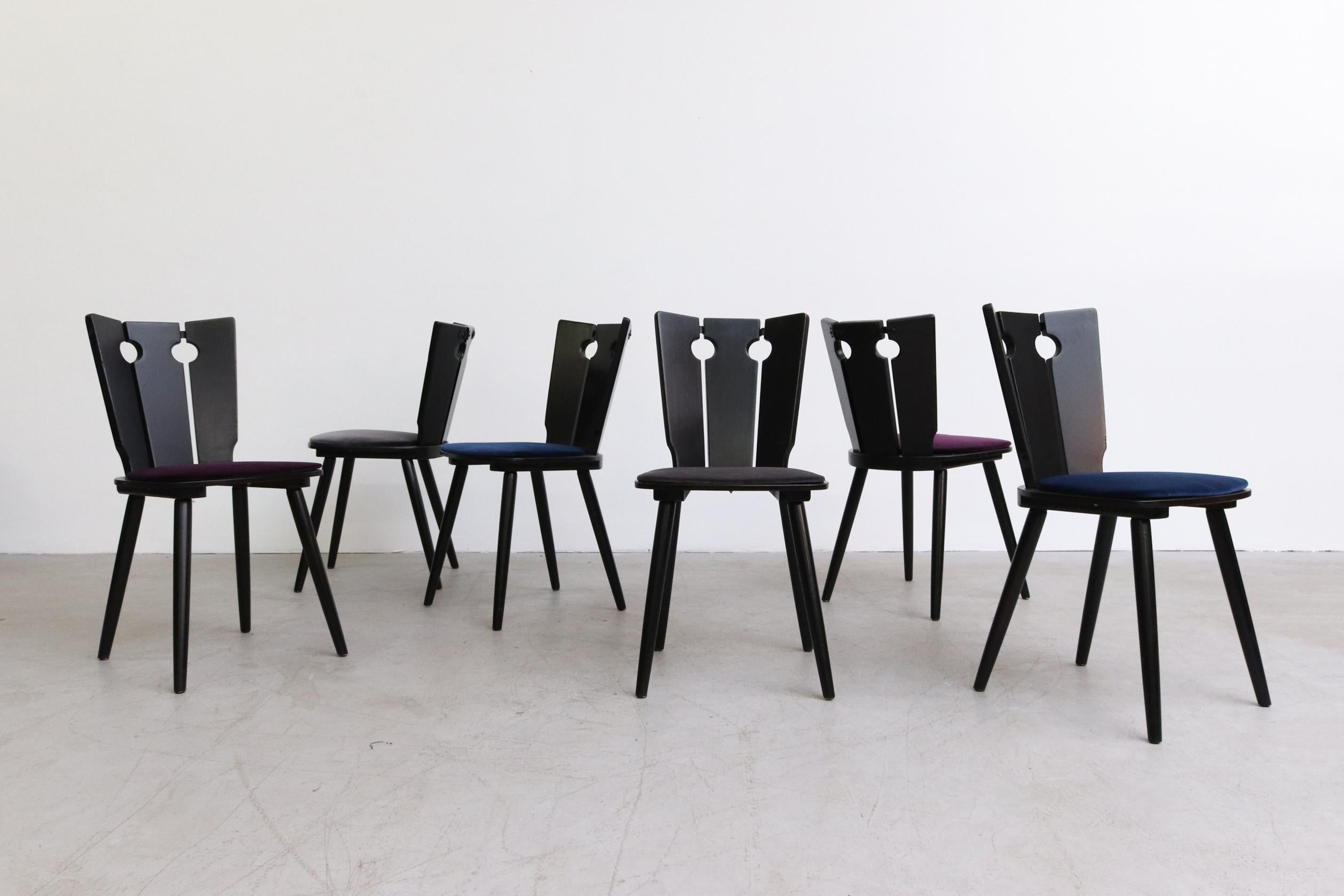 Ebony lacquered Brutalist dining chairs in the style of Gilbert Marklund. These have been outfitted with new velvet upholstered seats in blue, purple and grey (2 each). Original antique metal hardware on the back. Lightly touched up frames, in