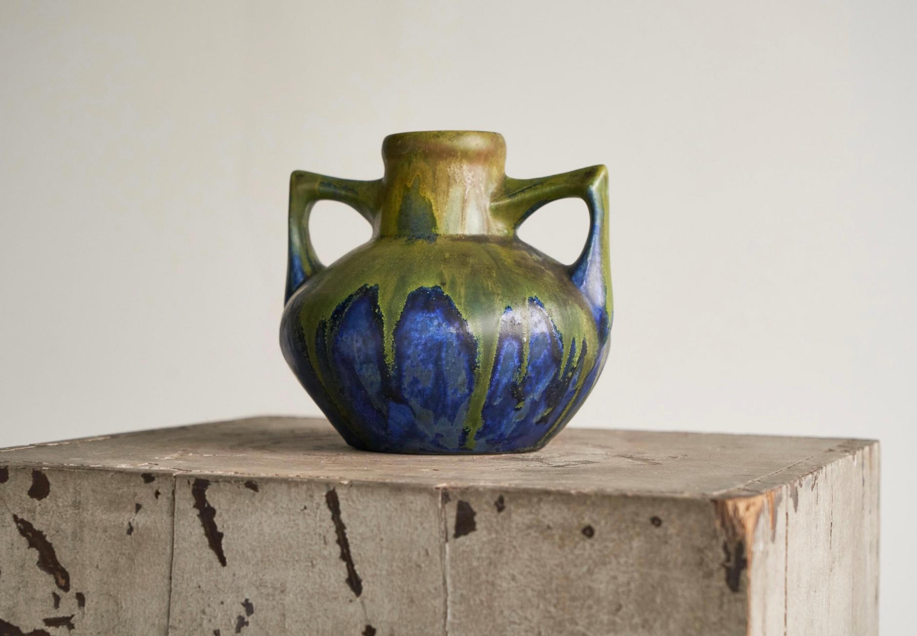 Ce magnifique vase Art déco est une pièce rare de l'artiste céramiste français Gilbert Méténier (France, 1844 - 1922).

Le vase est de bonne taille et présente deux poignées intéressantes qui se détachent doucement de la forme principale. Les