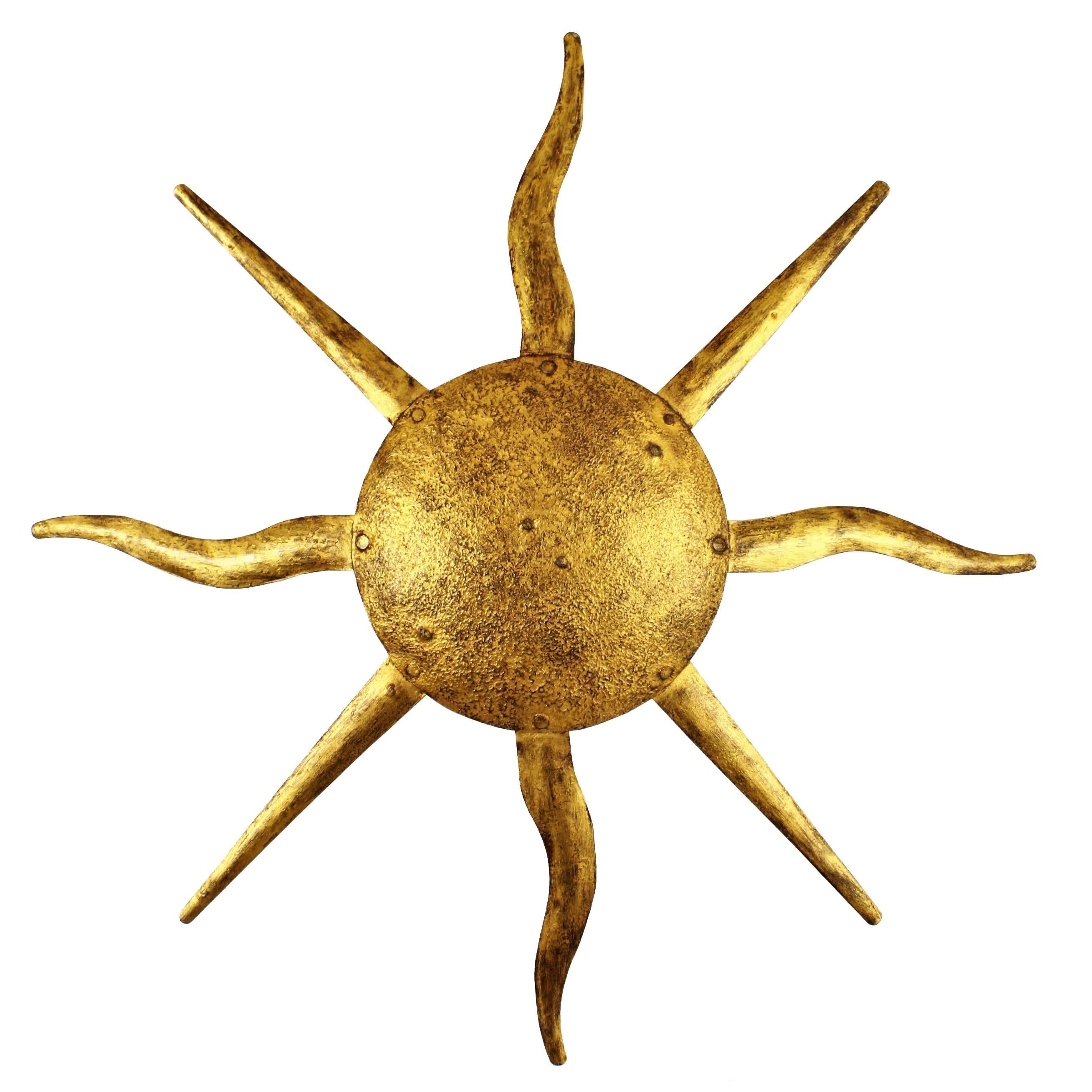 A hand-hammered iron sunburst wall sconce or ceiling light fixture with combined straight and curved beams and gold leaf finish in the style of Gilbert Poillerat. This piece wears its original vintage patina,
France, 1940-1950.
A highly decorative