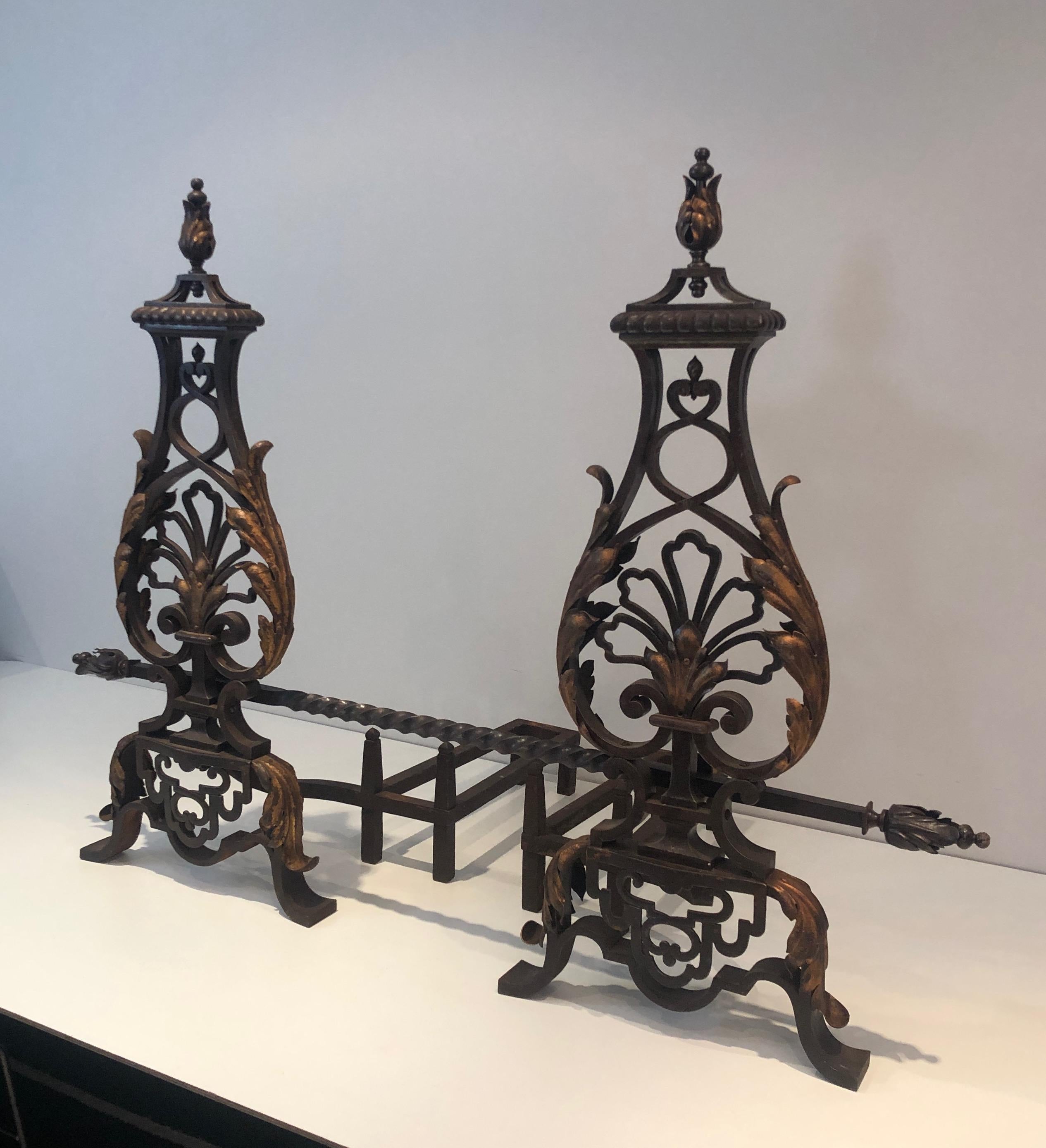 Amazing pair of important wrought iron and gilt iron andirons with twisted bar. These stunning andirons are French, in the style of so famous wrought iron master Gilbert Poillerat. This is a very fine wrought and fantastic wrought iron work, circa