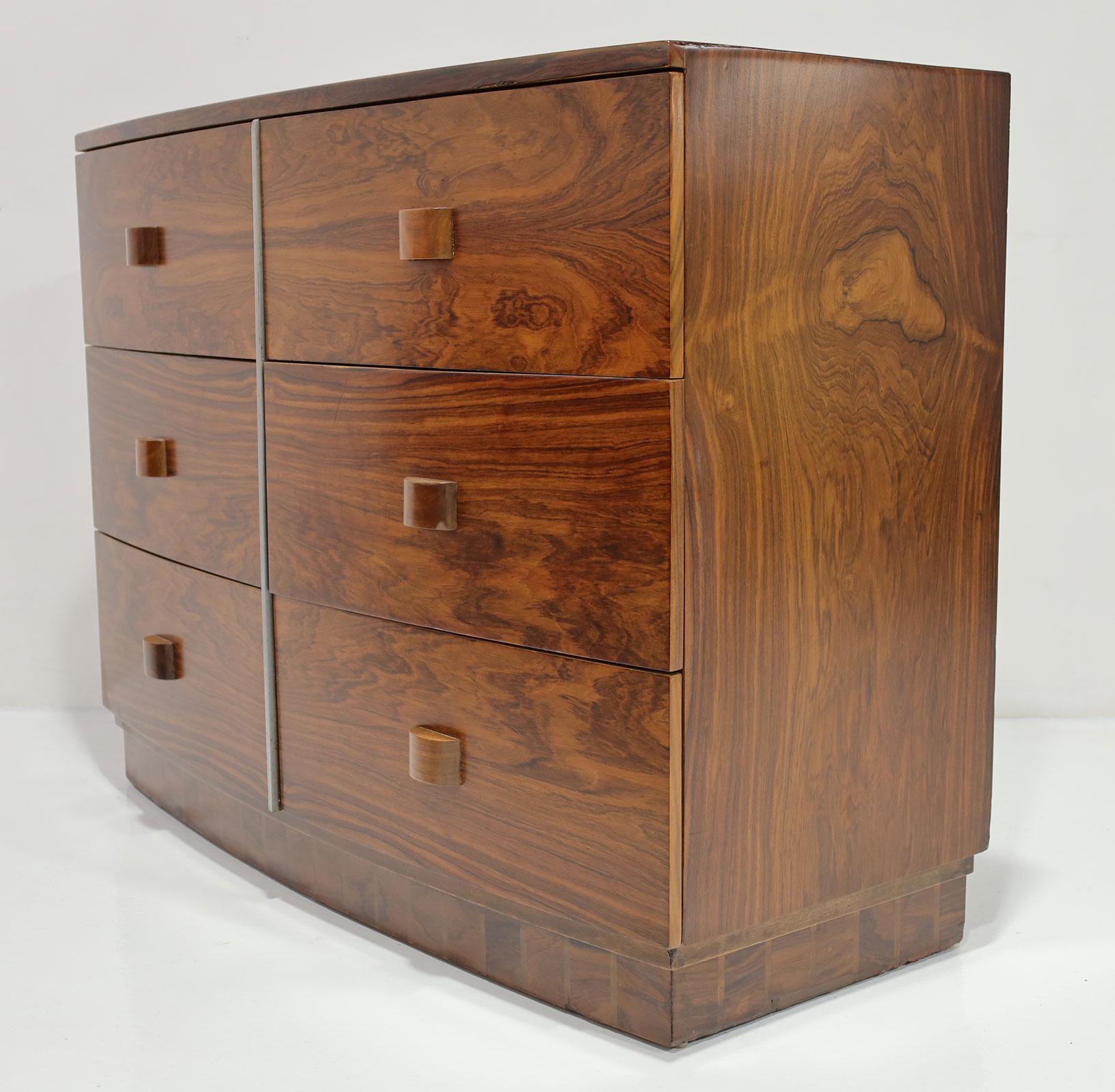 Eleva il tuo spazio con il comò a sei cassetti Gilbert Rohde #3770, uno squisito pezzo di storia realizzato per Herman Miller. Questo raro design è caratterizzato da una cassa curva in opulenta impiallacciatura di legno tropicale con maniglie in