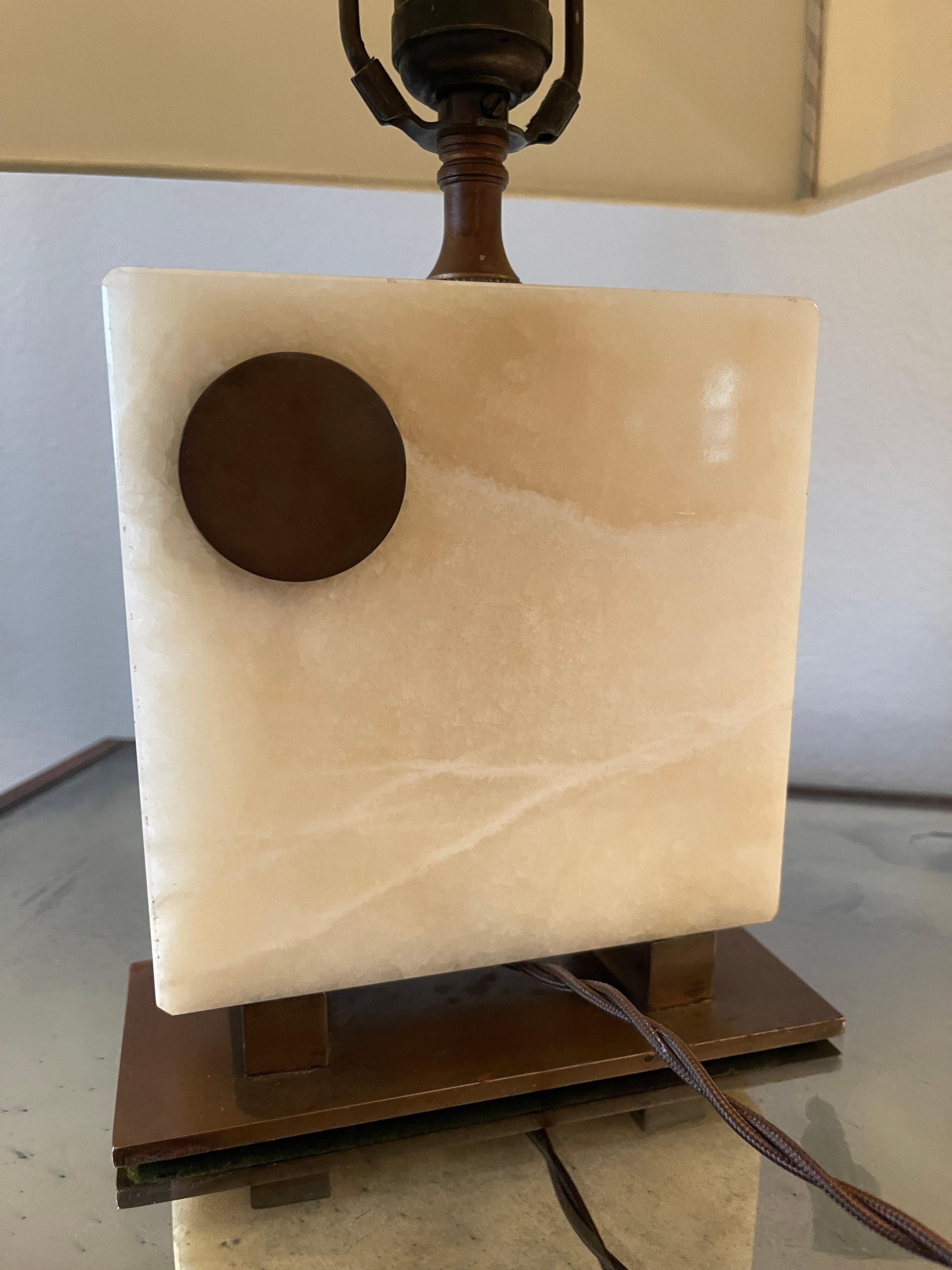 Rara lampada Art Deco in onice disegnata da Gilbert Rohde con base in rame. 
È stato ricablato con un cavo di stoffa marrone attorcigliato, come da progetto. Include l'attacco originale con interruttore in bachelite.
Il paralume misura 12