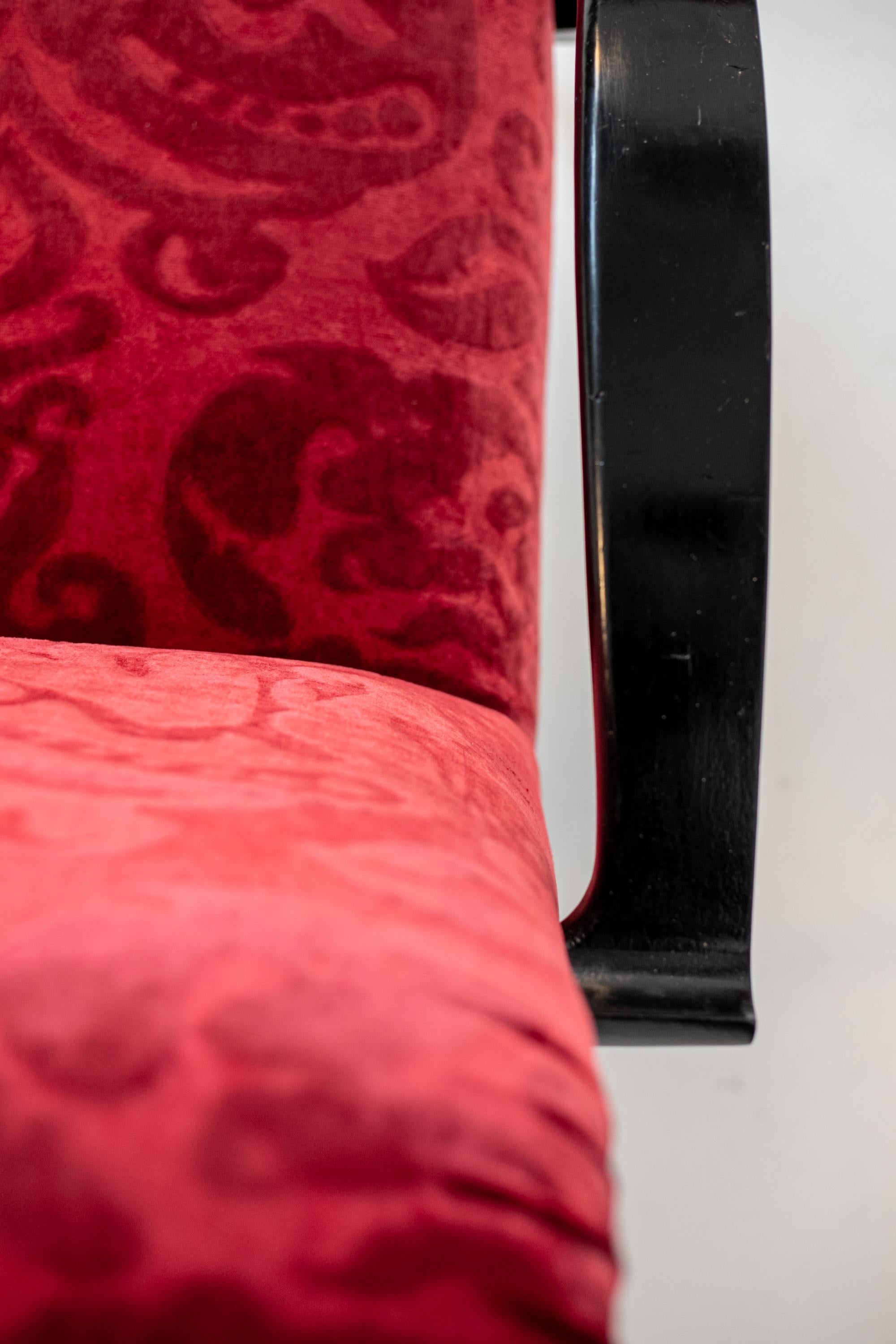 Außergewöhnliches Paar amerikanischer Sessel aus den 1950er Jahren, die Gilbert Rohde zugeschrieben werden. Das Sesselpaar ist aus einem sehr eleganten roten Damastsamt gefertigt. Die Armlehnen sind aus schwarz lackiertem Holz in halbgekrümmter